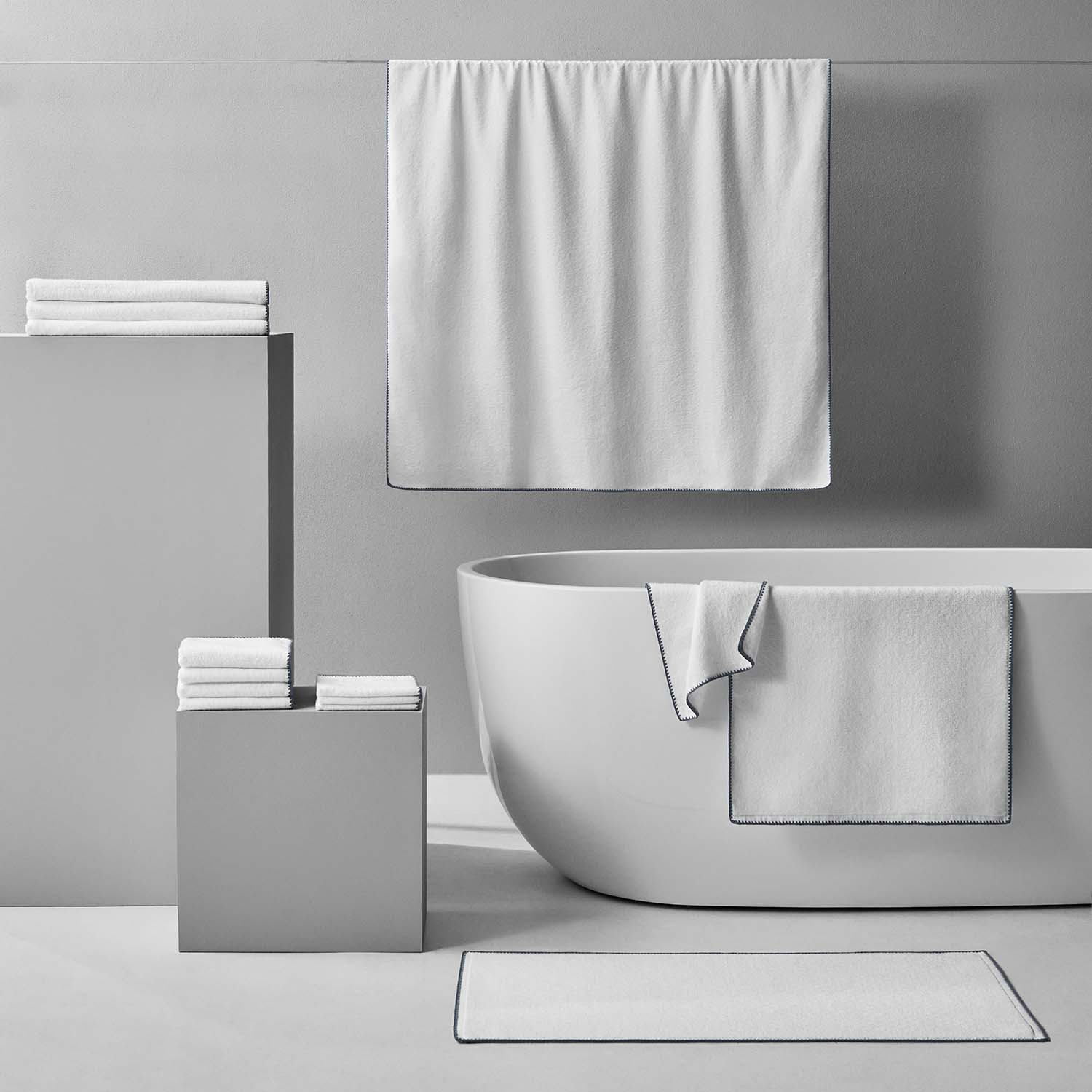Bordado towel with grey trim displayed with minimalist bathroom decor, emphasizing space-saving and eco-friendly features.