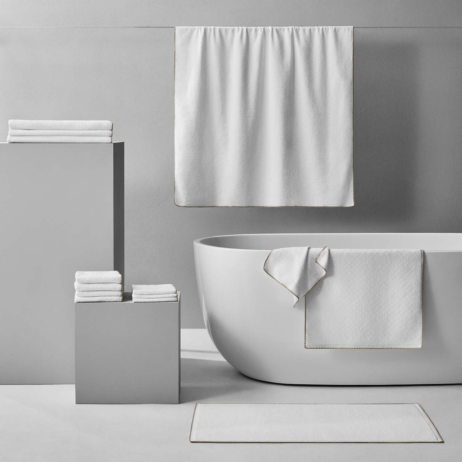 Bordado Towel Sand Trim displayed in a modern bathroom setting, showcasing plush design and space-saving features.