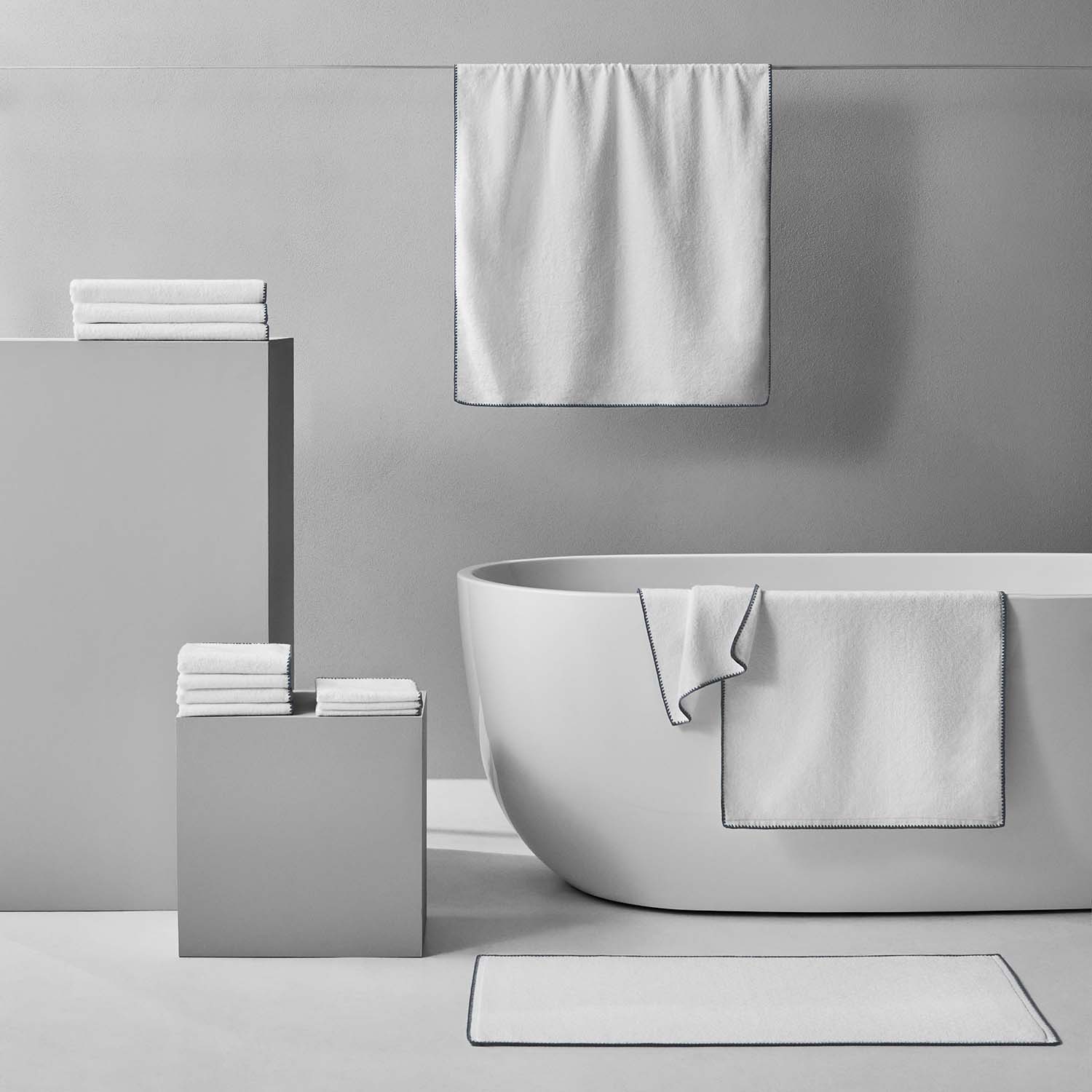 Bordado towel with grey trim displayed elegantly in a modern bathroom setting, showcasing plush, space-saving design.
