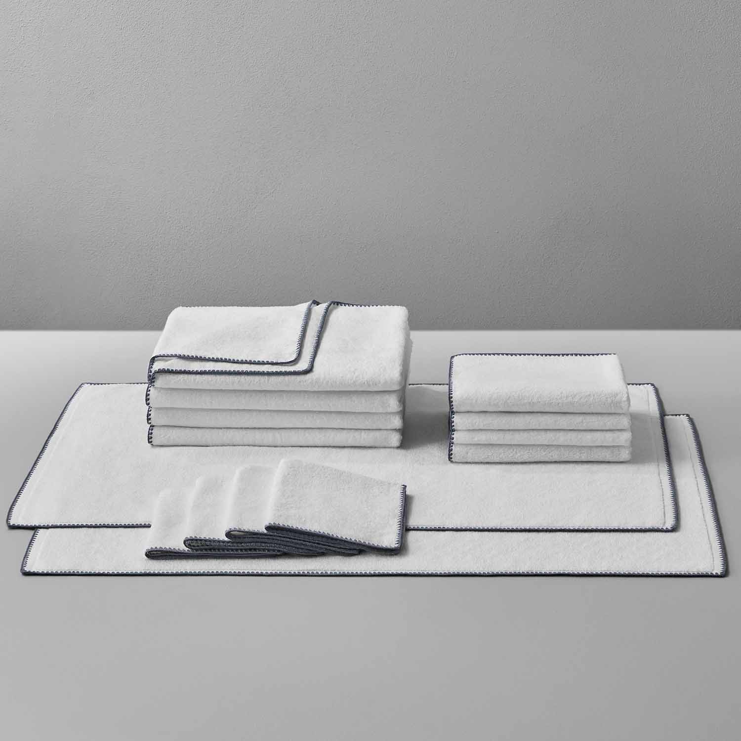 Bordado towel set with grey trim, featuring space-saving design and energy-efficient plush fabric for eco-friendly use.