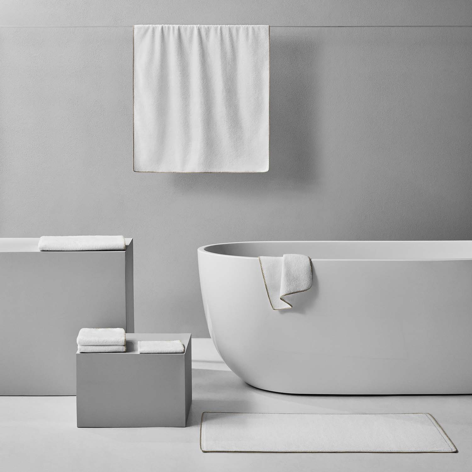 Bordado Towel Sand Trim displayed in a modern bathroom setting, showcasing its stylish design and space-saving features.