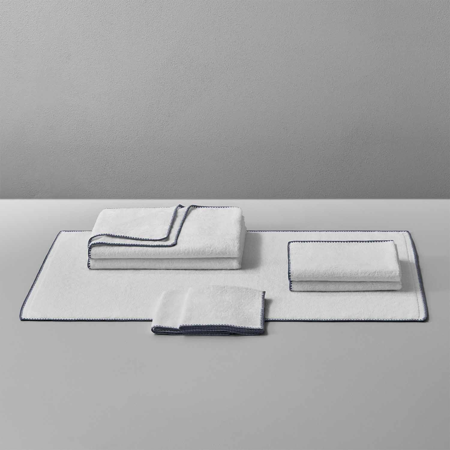 Bordado Towel set with grey trim, featuring space-saving design that uses 40% less water and electricity.