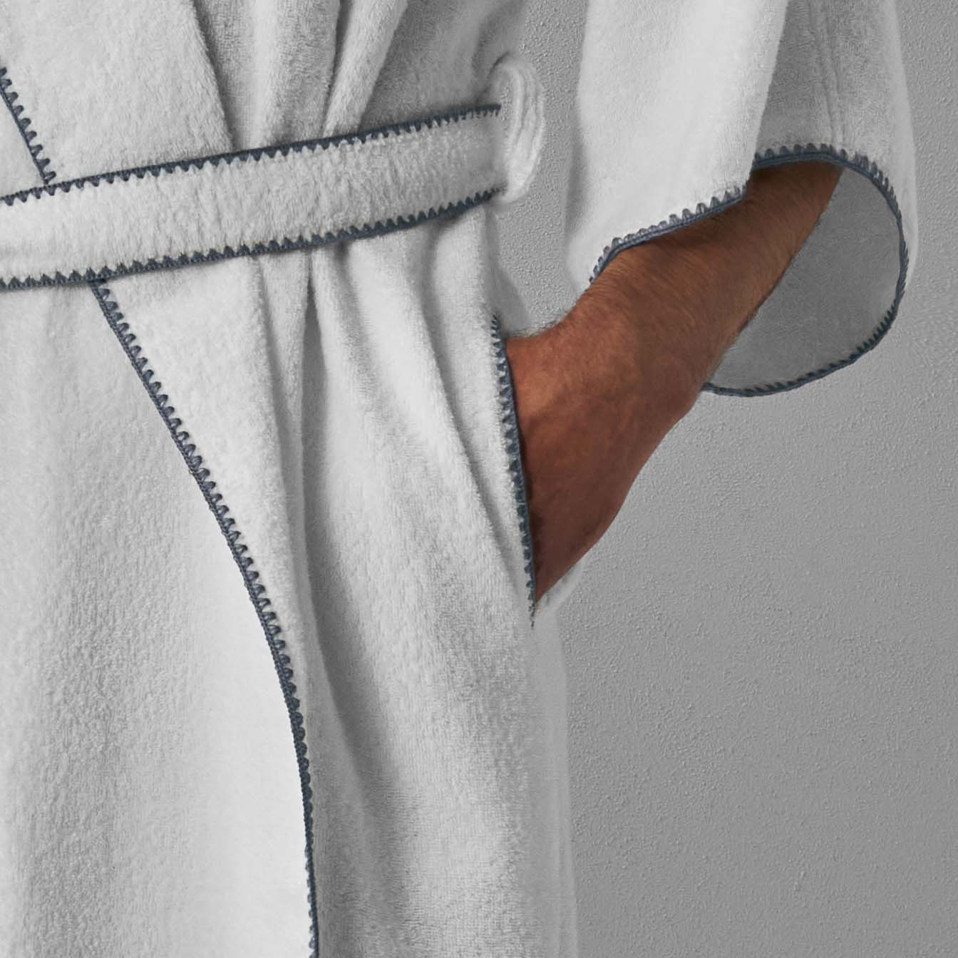 Detail of a Bordado hooded robe with gray trim, featuring a self-tie belt and pockets, perfect for luxury spa experiences.