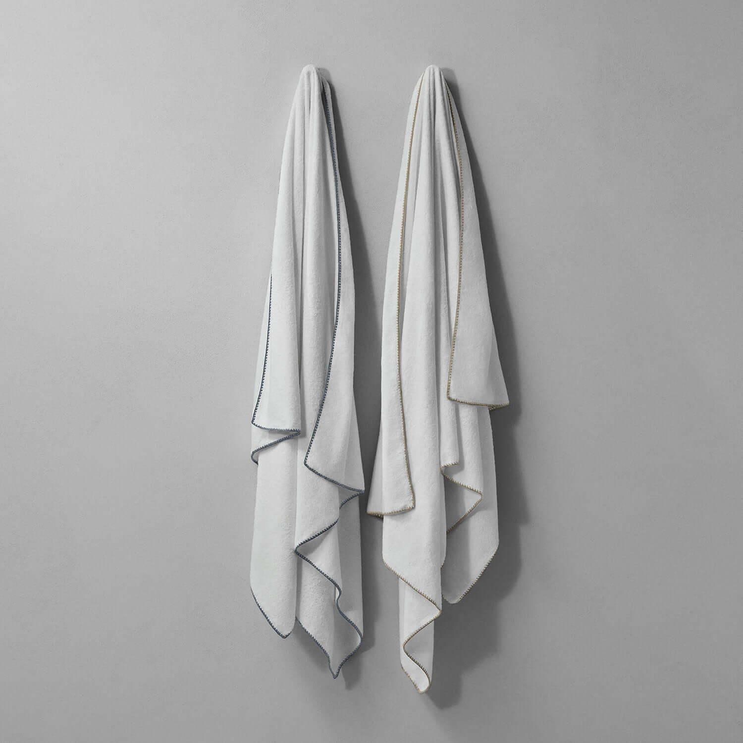 Bordado towel with grey trim, showcasing its thin plush design for eco-friendly washing and space-saving storage.