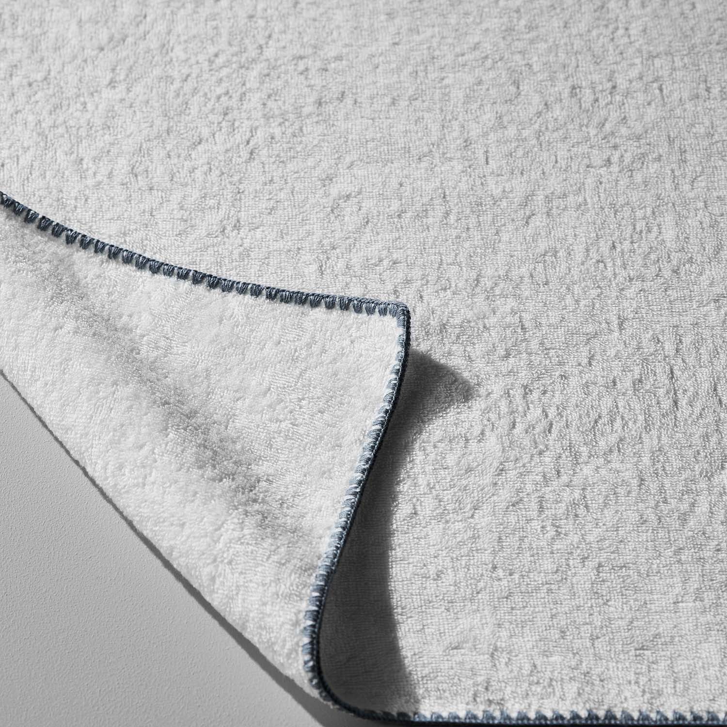 Bordado Towel with Grey Trim, thin plush design, eco-friendly, space-saving, uses less water and energy.