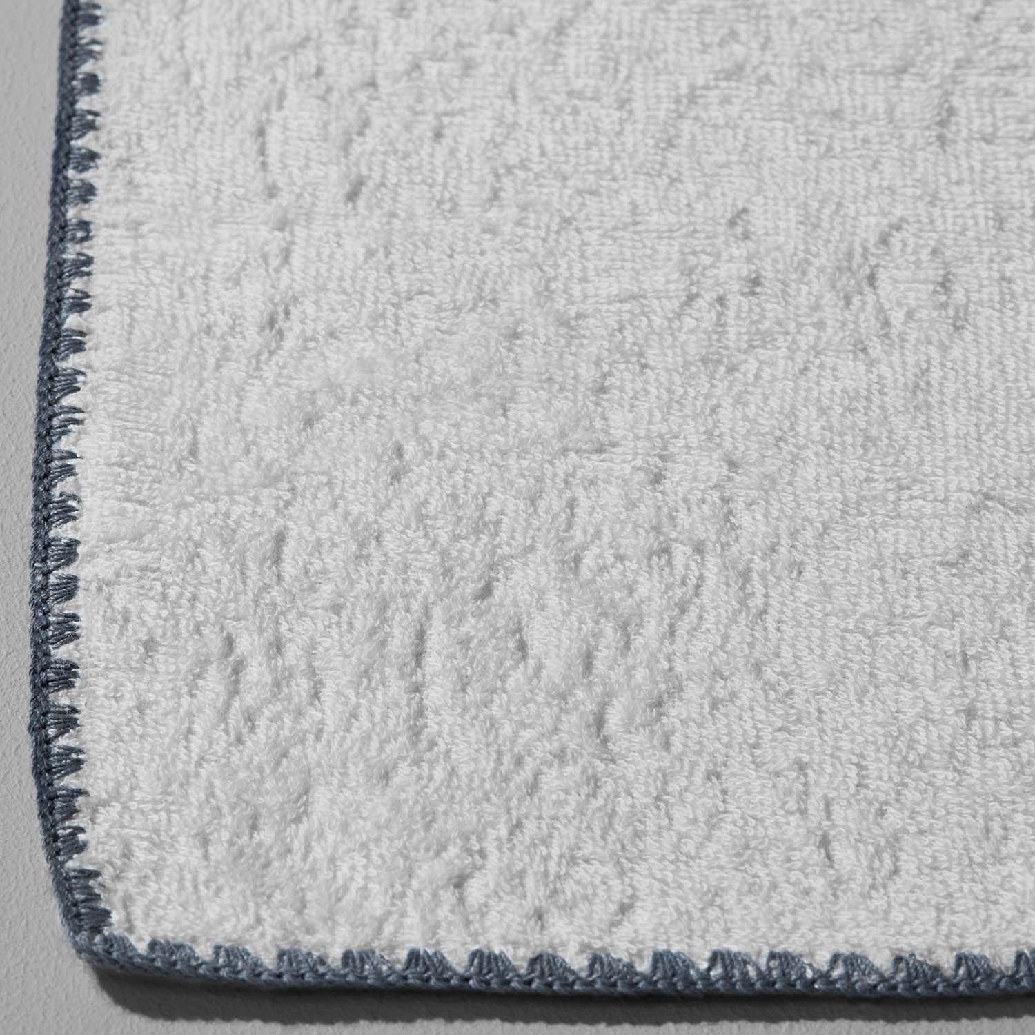 Close-up of a Bountiful Bordado towel featuring millennial-grey stitching, showcasing its plush texture and absorbent quality.