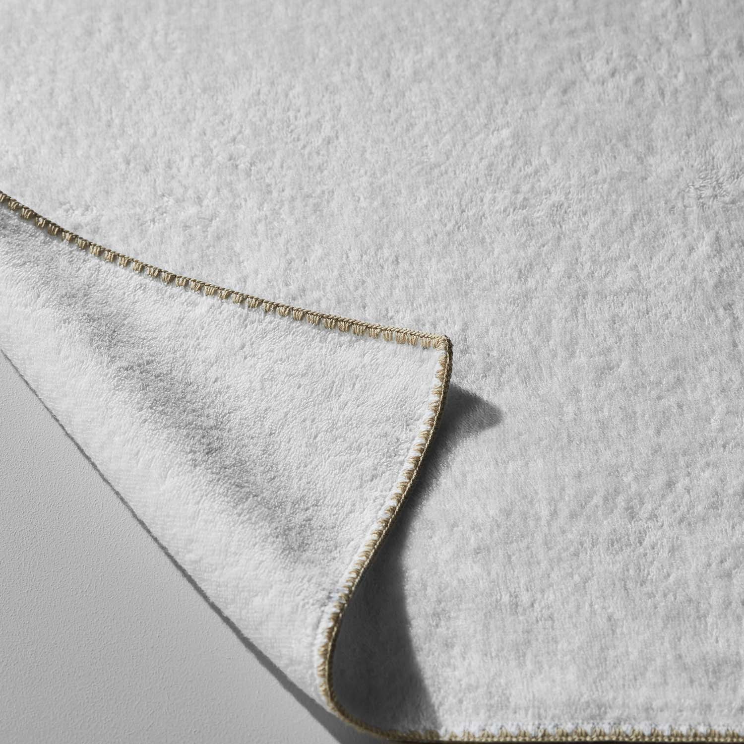 Bordado Towel Sand Trim, plush towel with delicate sand-colored trim, designed for space-saving efficiency and eco-friendliness.