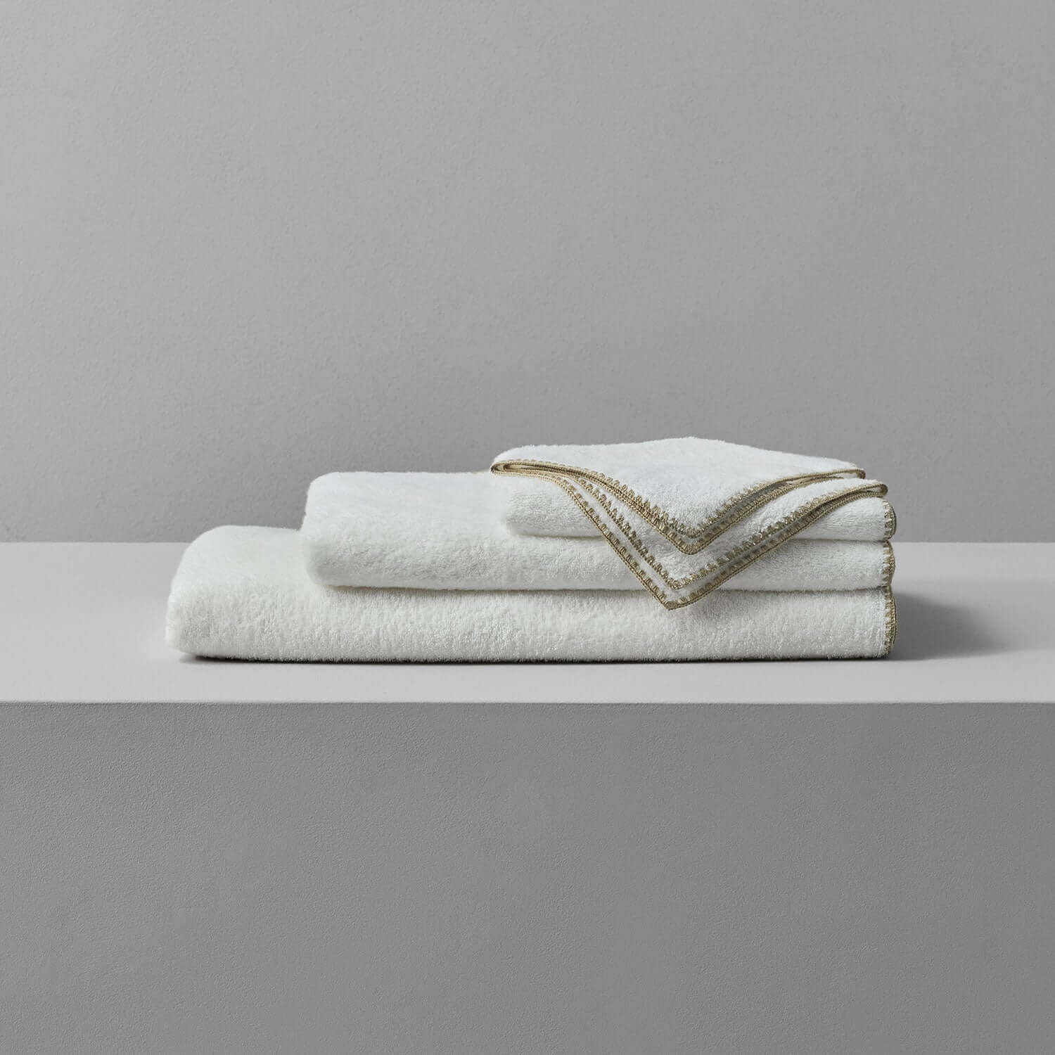 Bordado towel with sand trim, perfect for space-saving storage and eco-friendly laundry, using less water and energy.