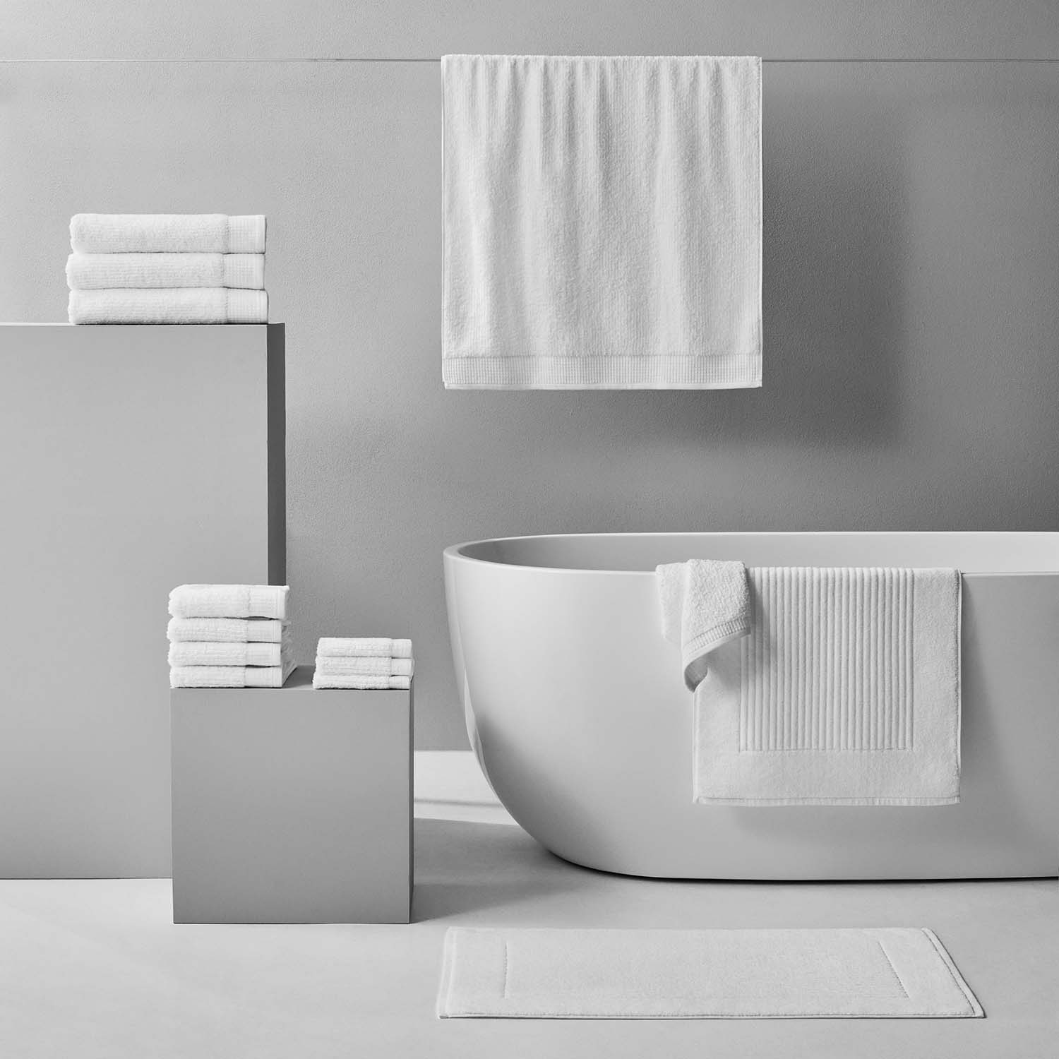 Luxor Towel display in a modern bathroom setting, featuring plush Egyptian Cotton™ towels in white.