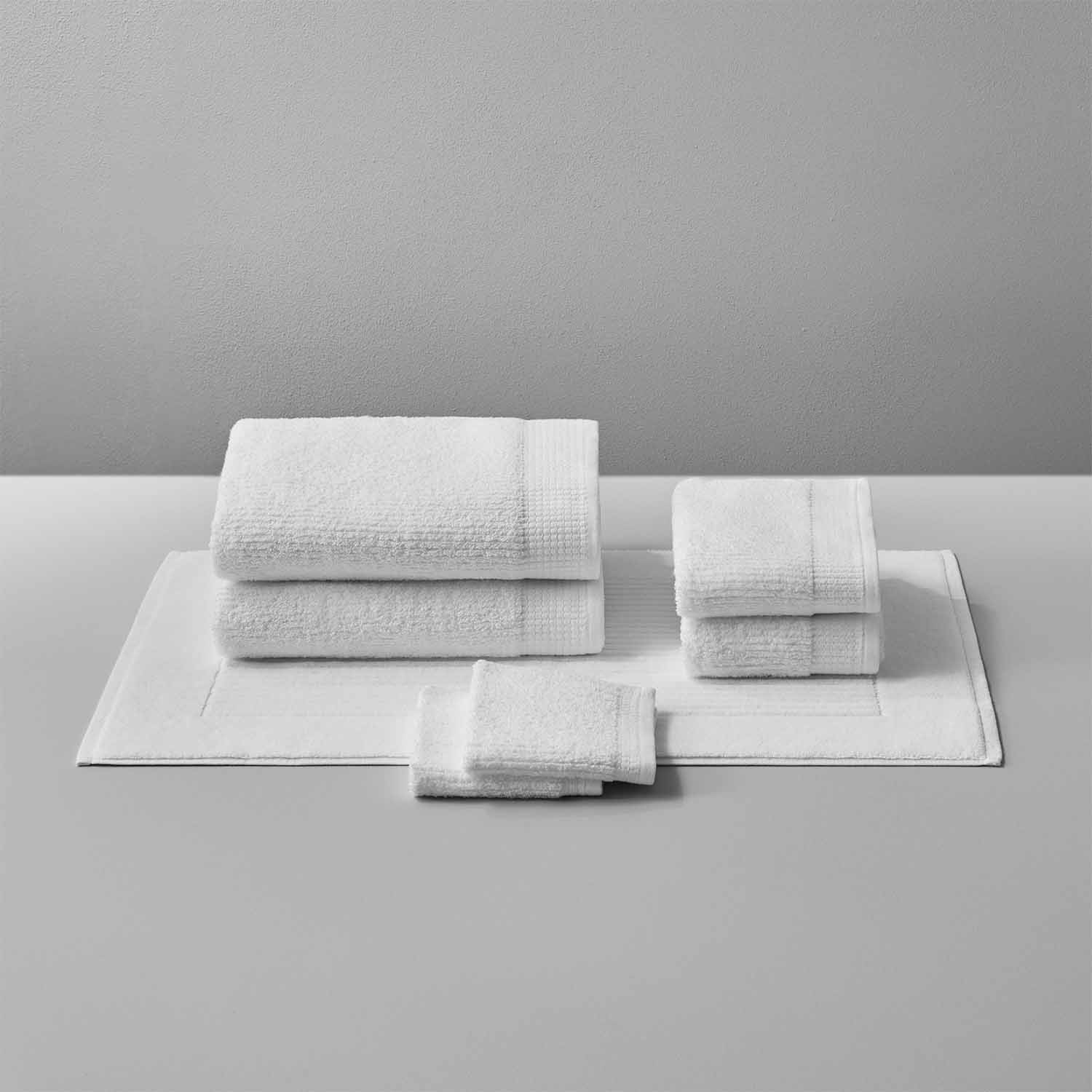 Luxor Towel set featuring plush Egyptian Cotton™ towels stacked elegantly on a soft gray surface.