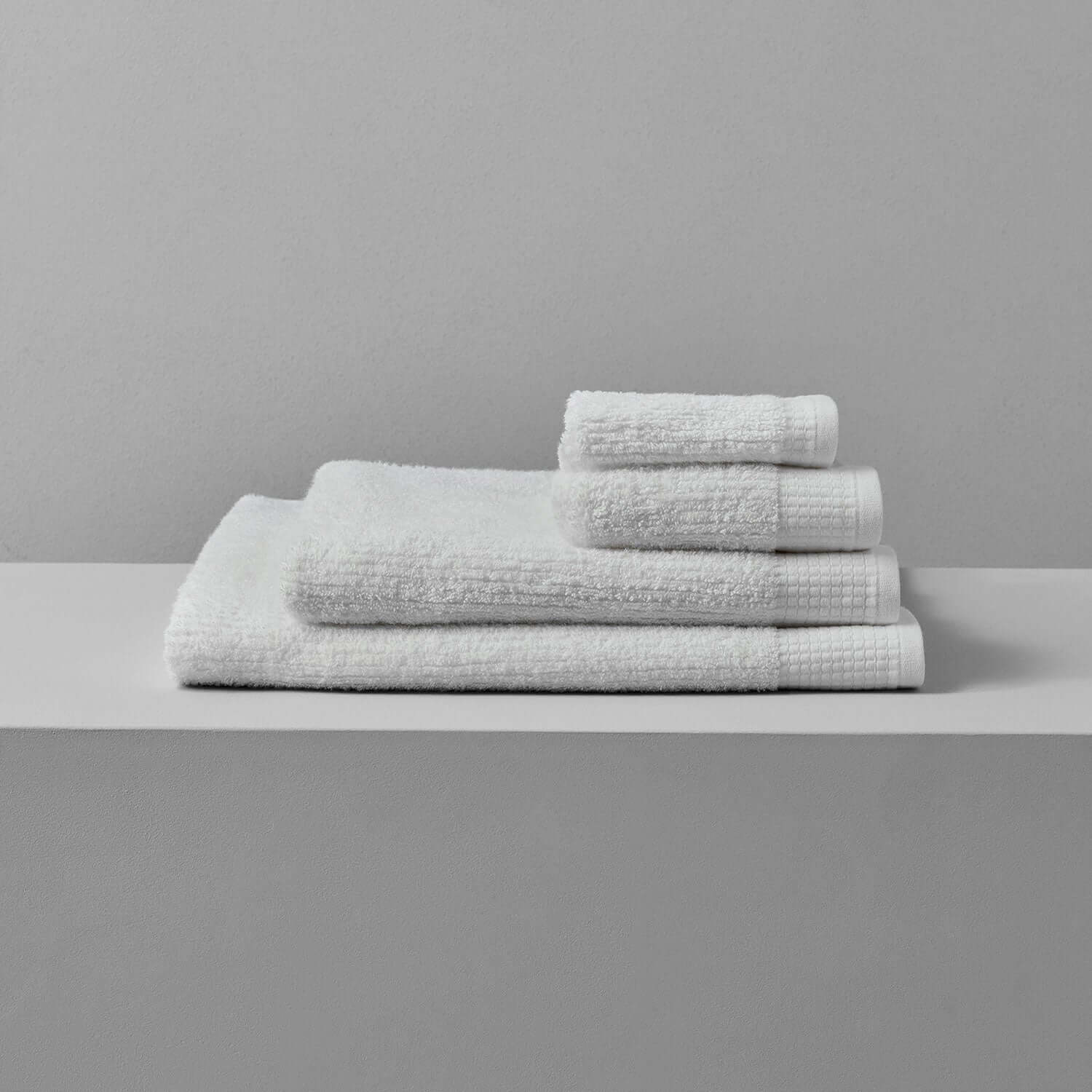 Luxor Towel set displayed on a minimalist shelf, showcasing plush Egyptian cotton towels for ultimate comfort.