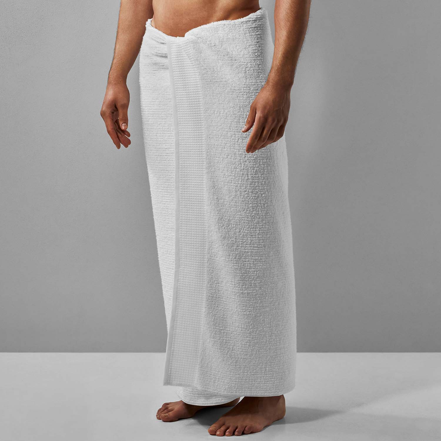 Man wearing a plush white Luxor Towel made from authentic Egyptian Cotton™, ideal for luxury home use.