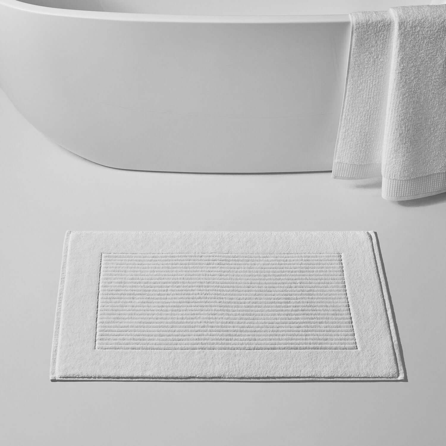 White velour mat displayed in a modern bathroom, showcasing its luxurious texture and slip-resistant design.
