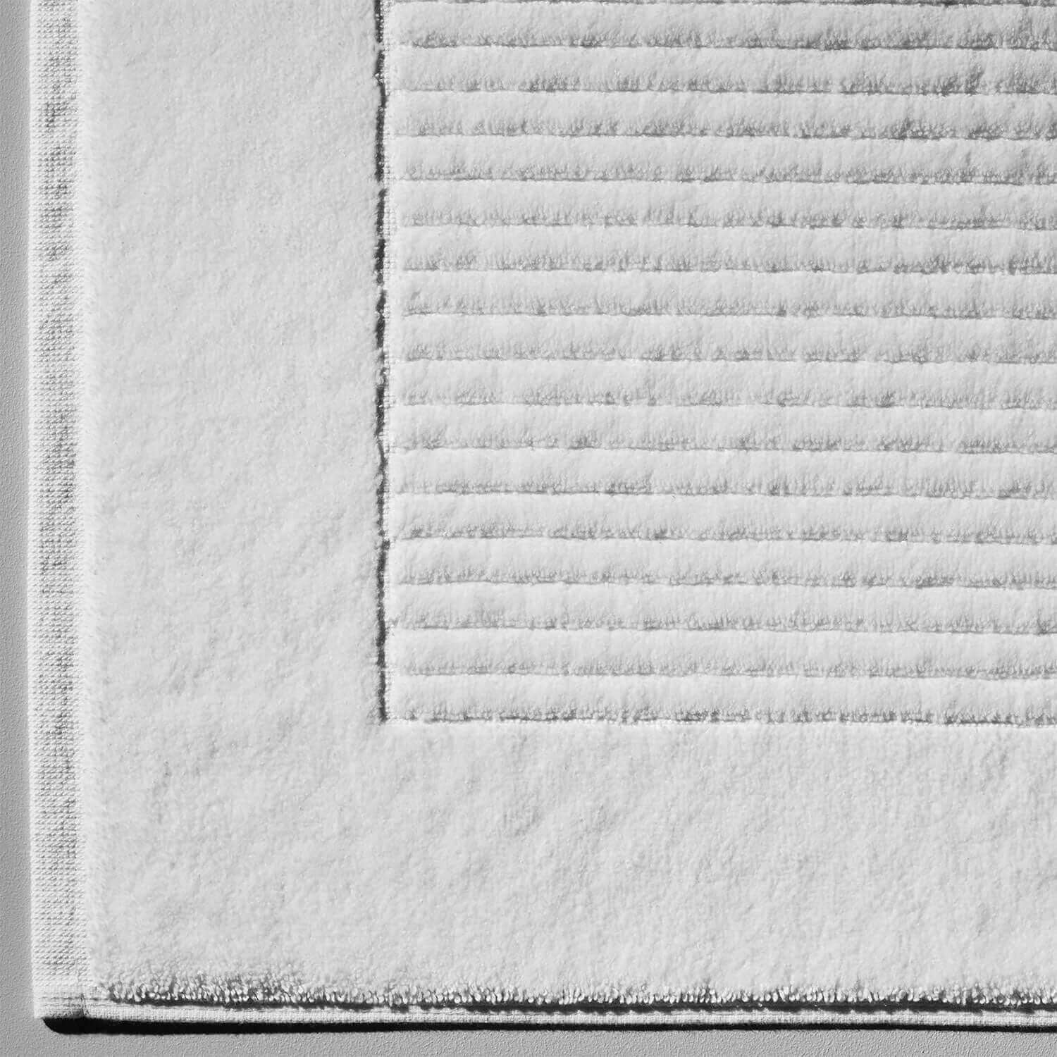 Close-up of a luxurious white velour mat, showcasing its soft texture and contemporary design.