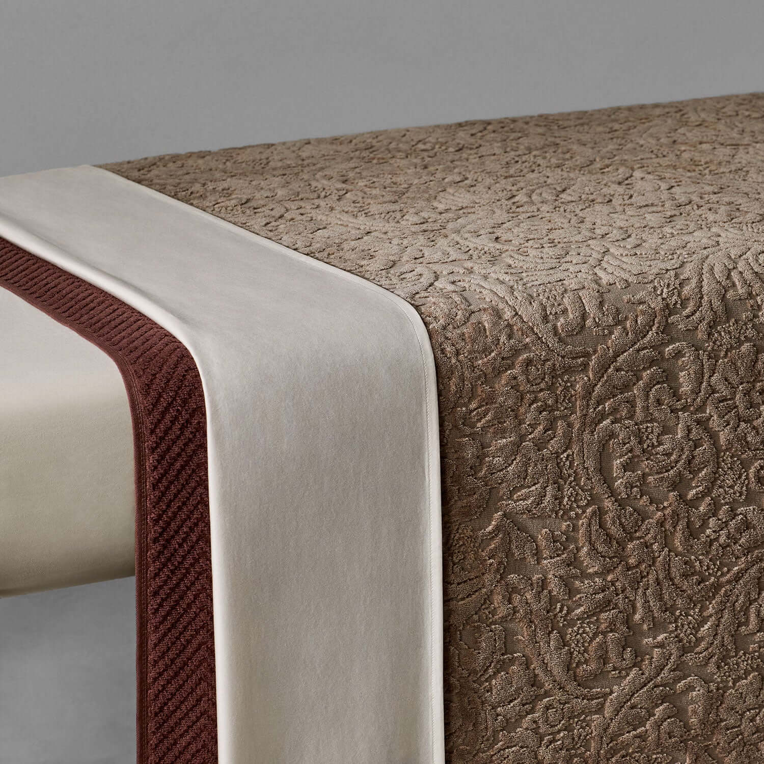 Baroque blanket in chocolate velour with cream trim, showcasing a luxuriously soft texture for bedding and outdoor use.
