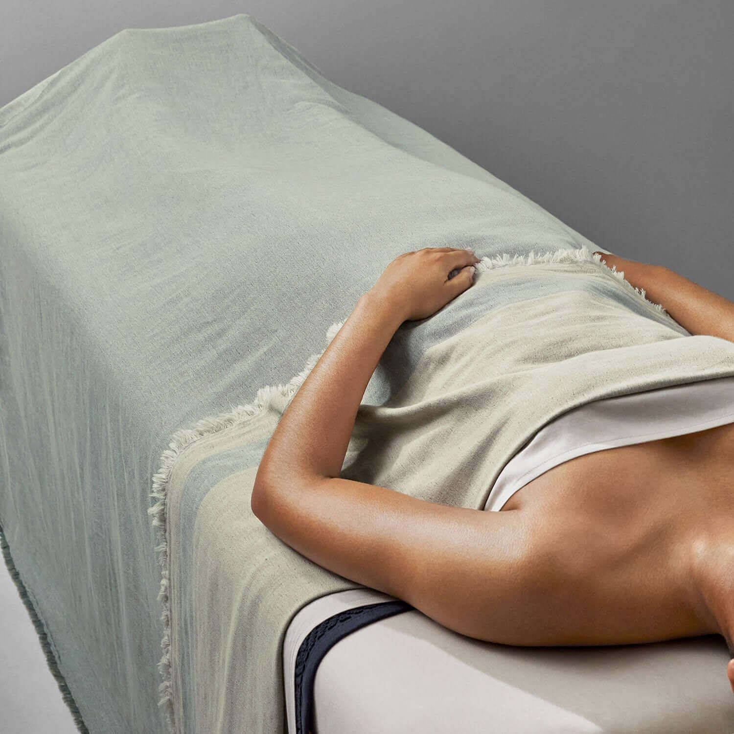 Relaxing with a two-toned Cenote blanket during a spa treatment, showcasing comfort and eco-friendly elegance.