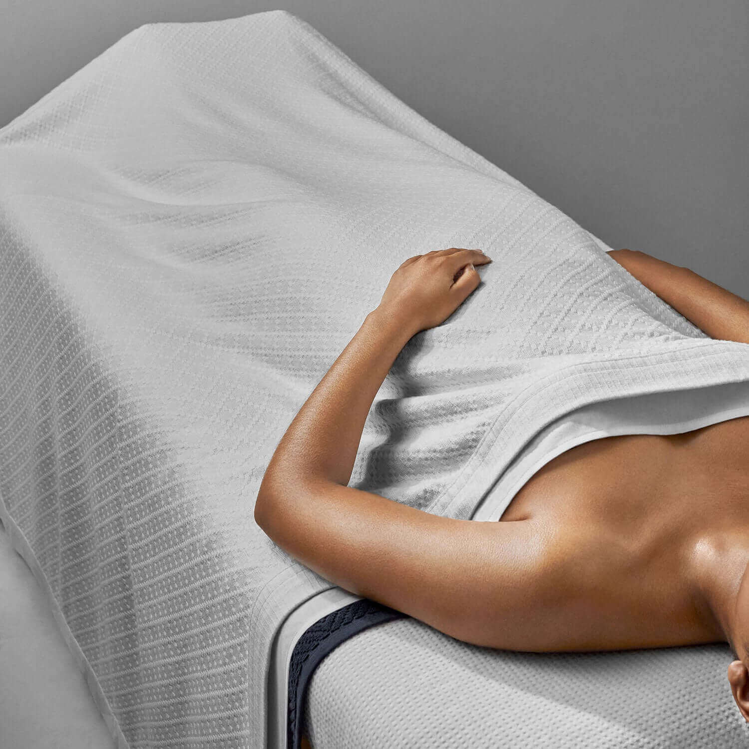 Lightweight cotton blanket draped on a spa table, showcasing comfort and timeless design for relaxation.