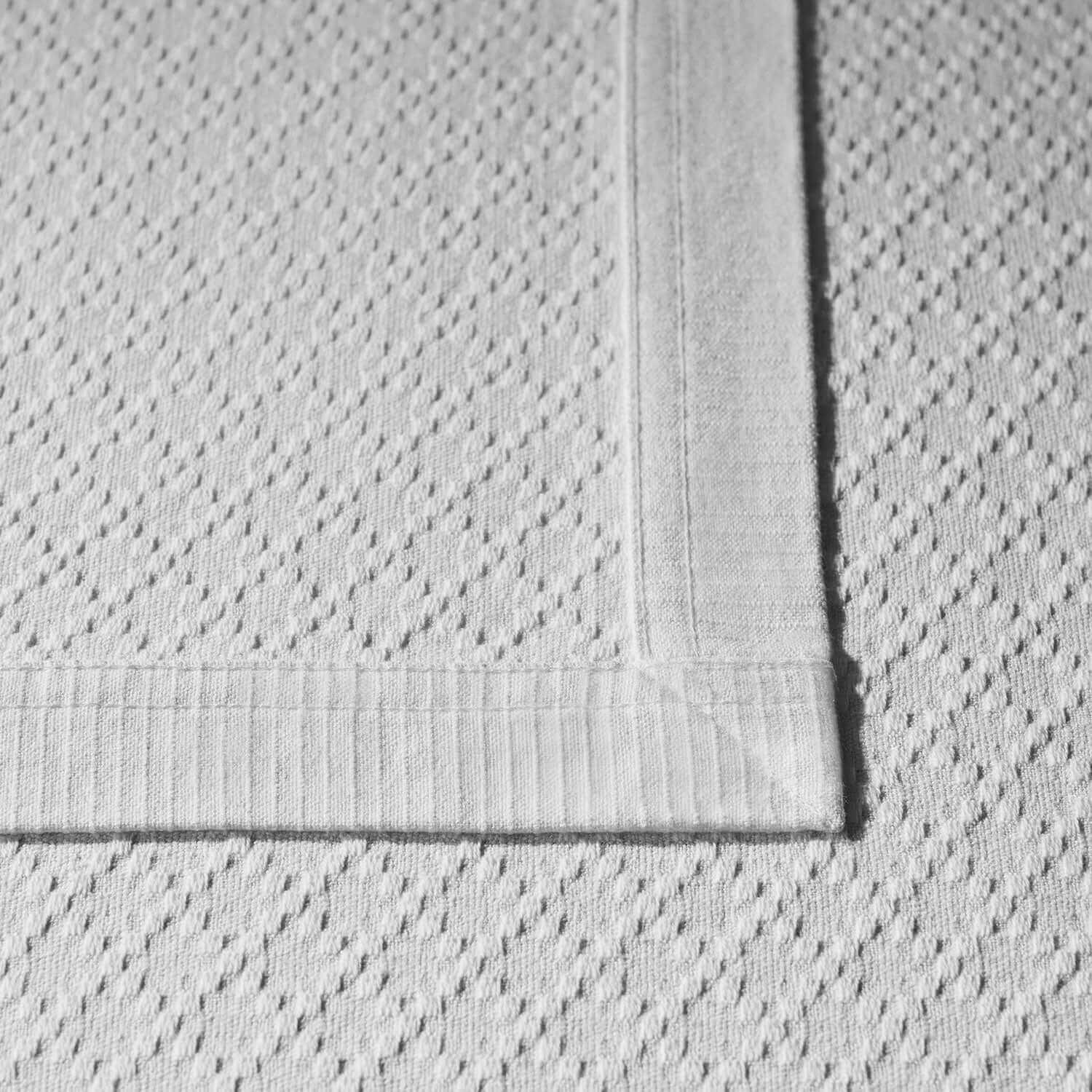 Close-up of a lightweight cotton blanket with a double-wide hem, showcasing its timeless and classic design.
