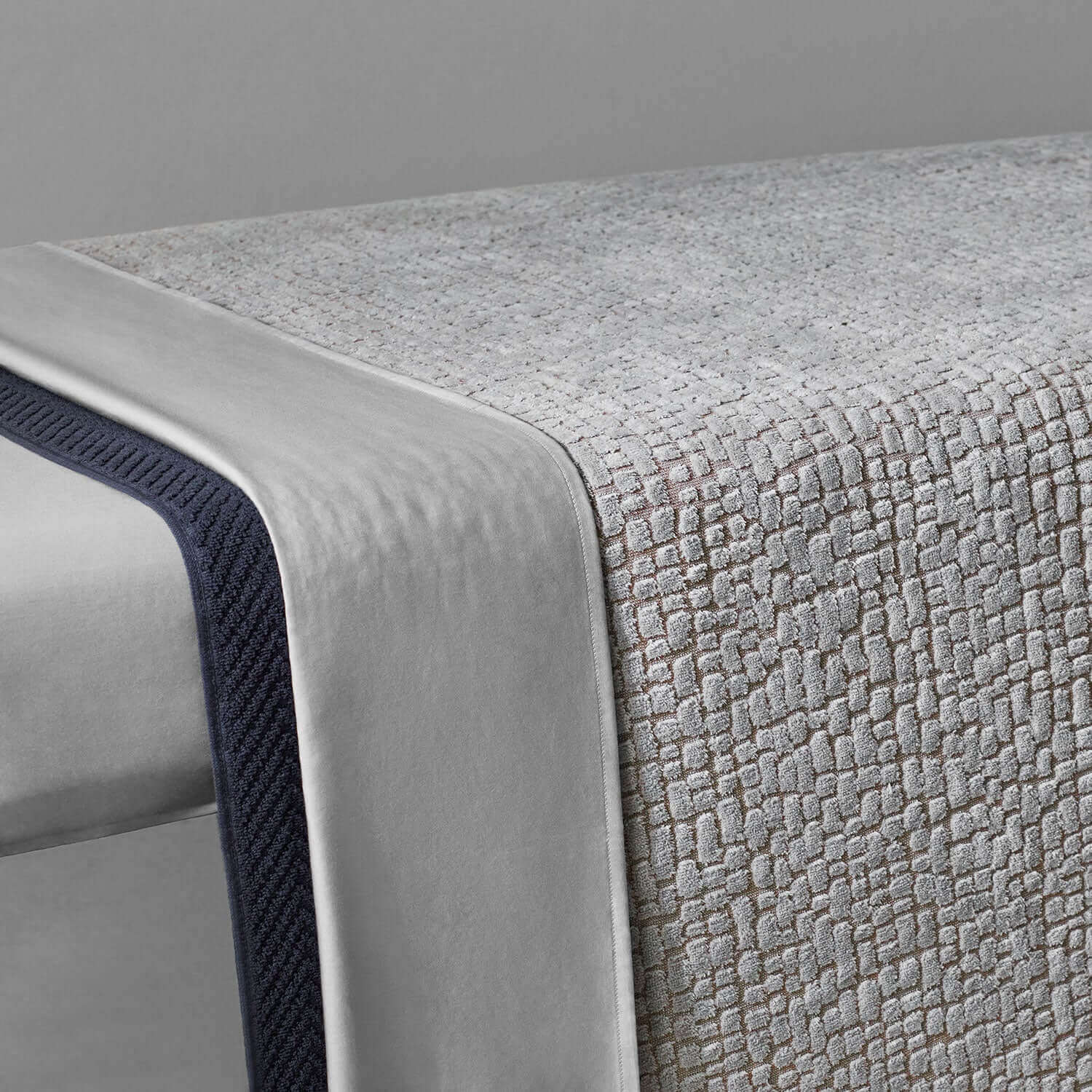 Pebble Blanket Gray on a spa table, showcasing its textured design and durable cotton construction.