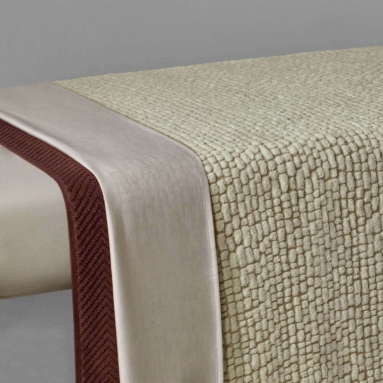 Pebble blanket in soft beige with textured design and elegant satin border, ideal for spa and relaxation settings.
