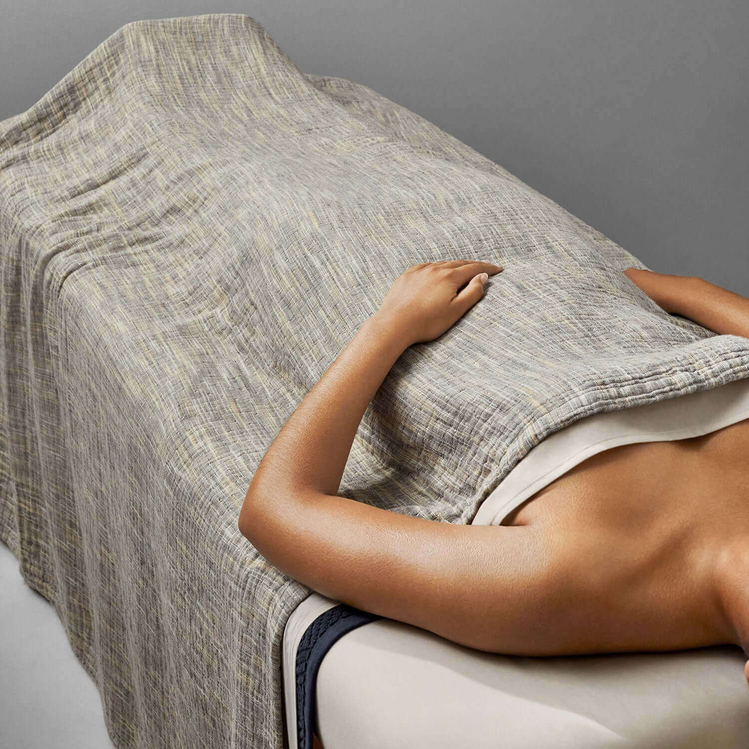 Unique printed yarn blanket draping over a massage table, showcasing artisanal craftsmanship and comfort.