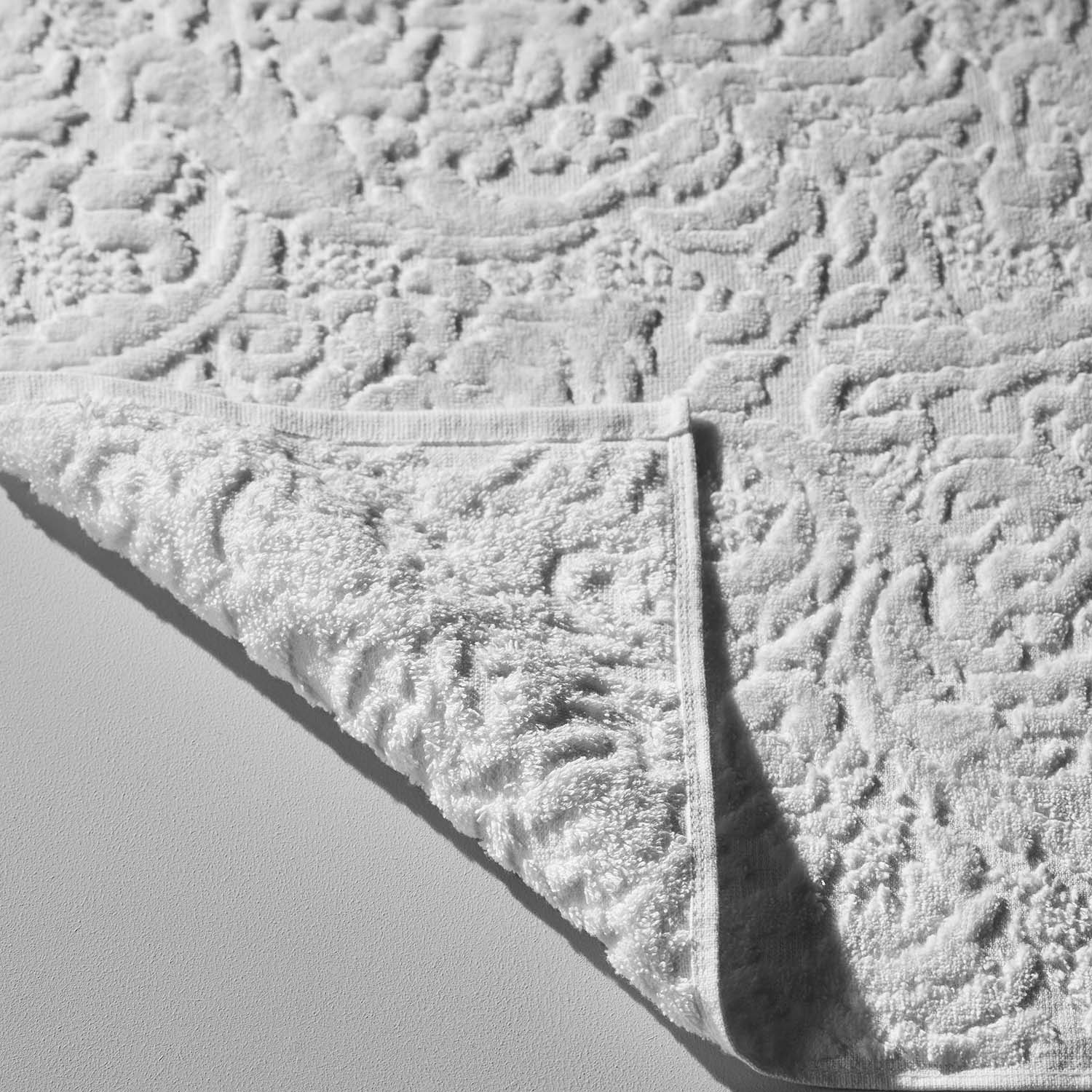 Close-up of a white Baroque velour blanket showcasing its plush texture and intricate pattern.