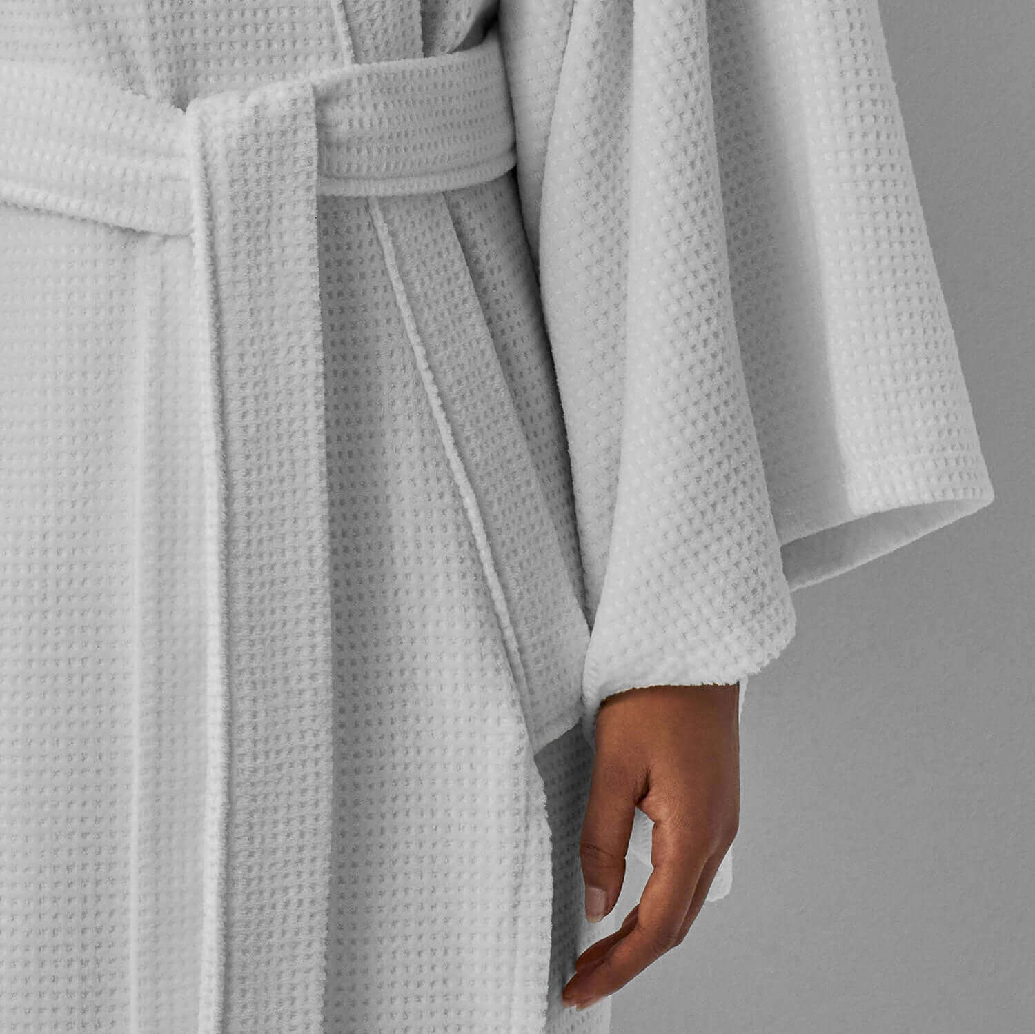 Close-up of a soft velour kimono robe with dimpled pattern, showcasing stylish sleeves and hidden pockets.