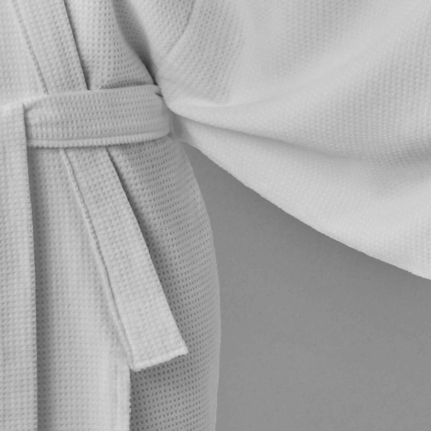 Close-up detail of a white velour kimono wrap showcasing soft texture and stylish belt tie.