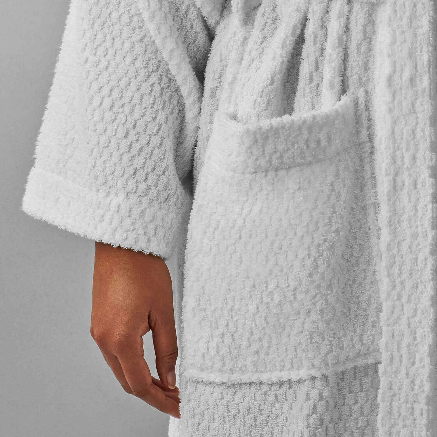 Soft-touch white kimono robe with braided neckline detail and a front pocket for a luxurious spa experience.