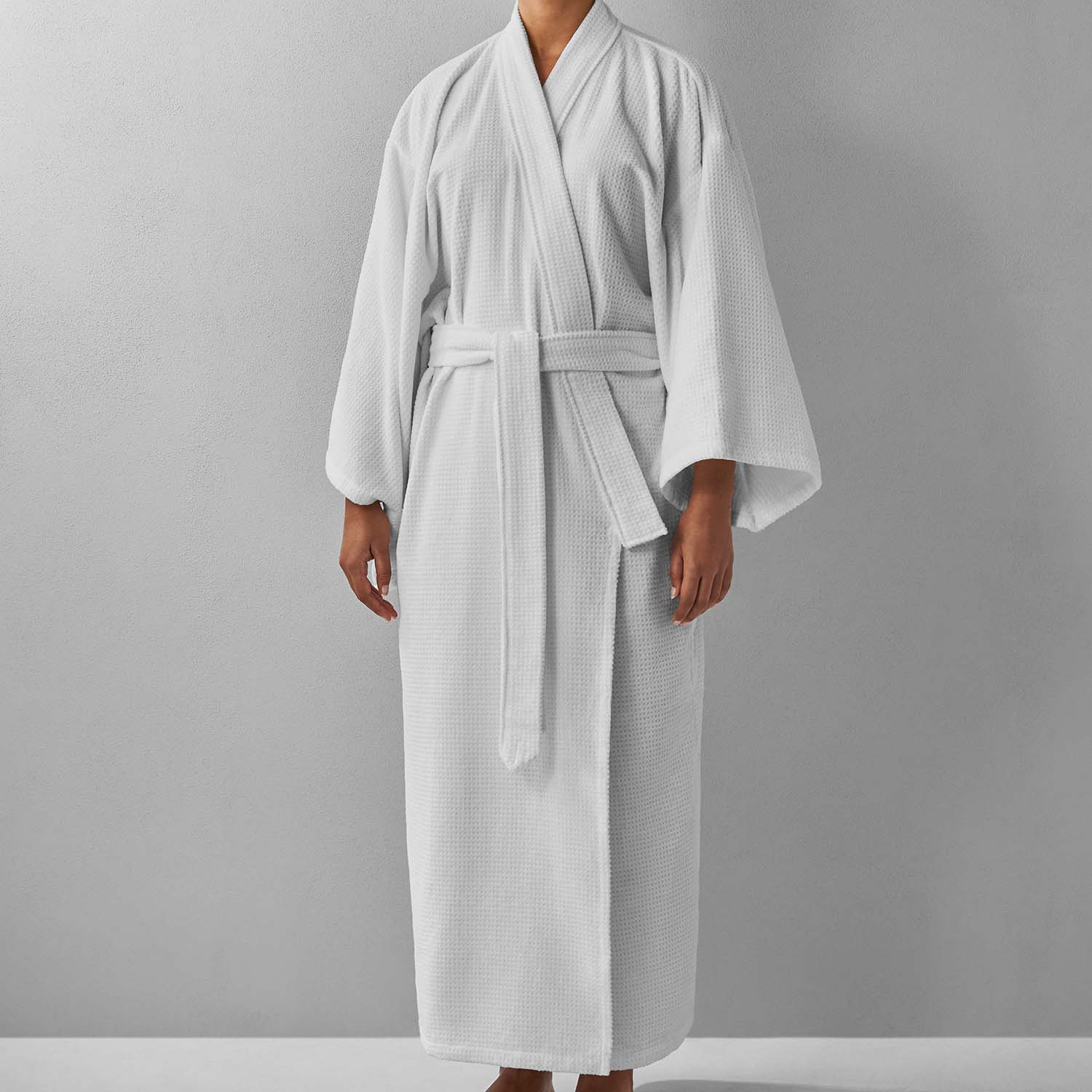 Elegant white novotel kimono robe with statement sleeves and pockets, perfect for spas and resorts.