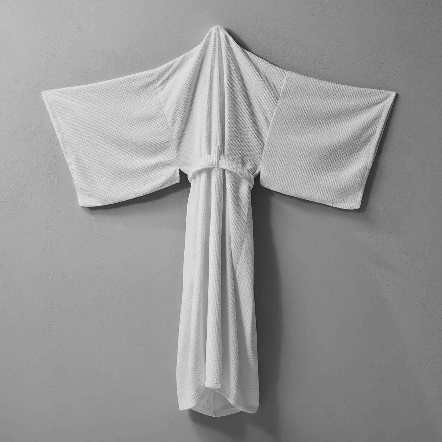 White Novotel Kimono with statement sleeves and hidden pockets, showcasing soft velour texture and chic design.