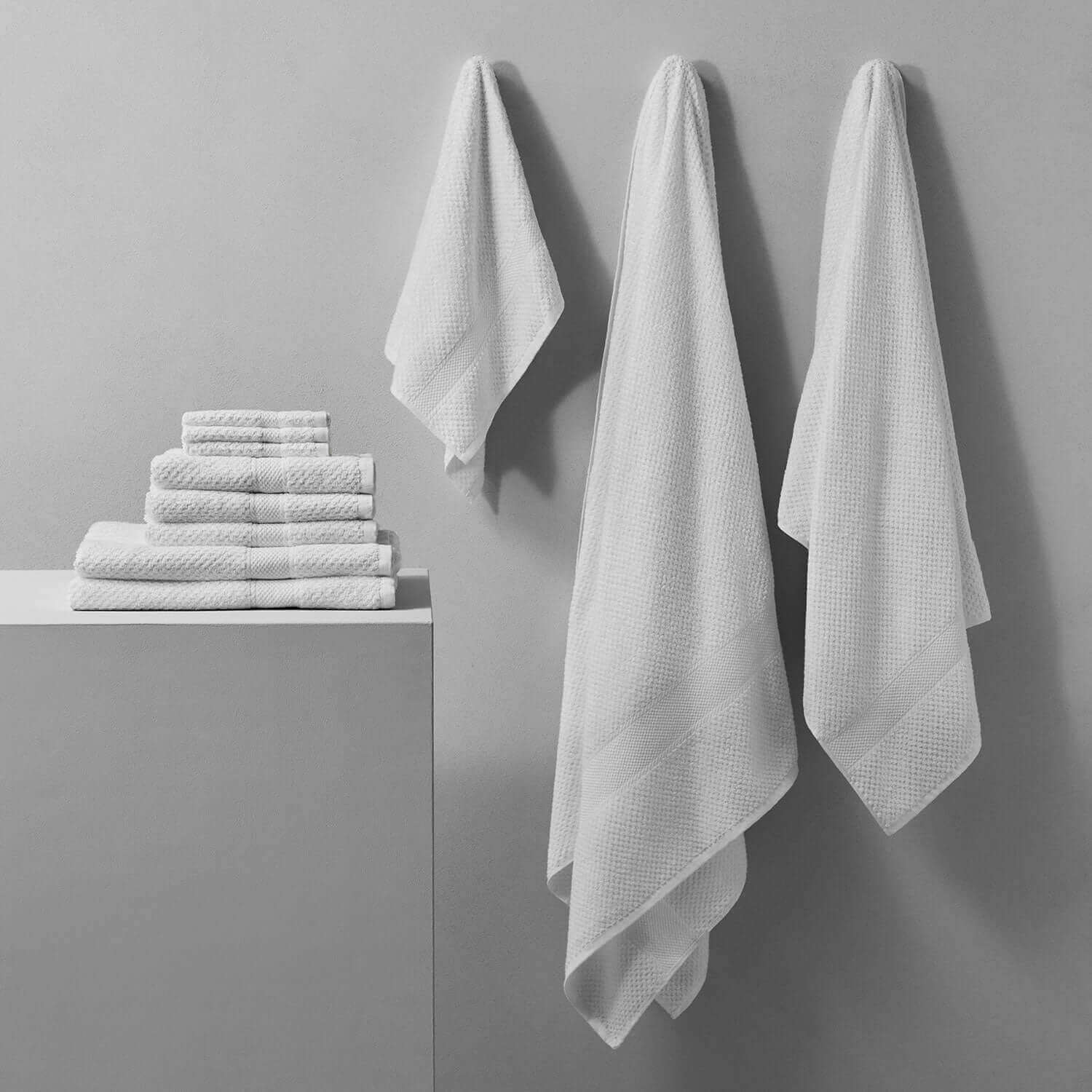 Novotel Towel collection hanging and stacked, showcasing 100% long-fibre Brazilian cotton for luxury performance.