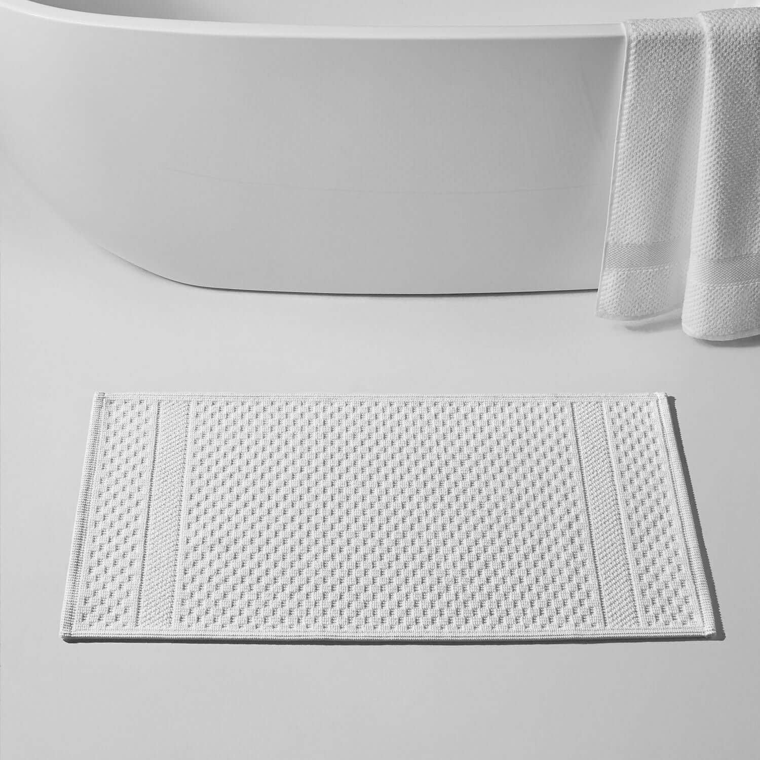 Novotel Mat Wholesale: textured white mat beside a modern bathtub, perfect for luxury hotels and spas.