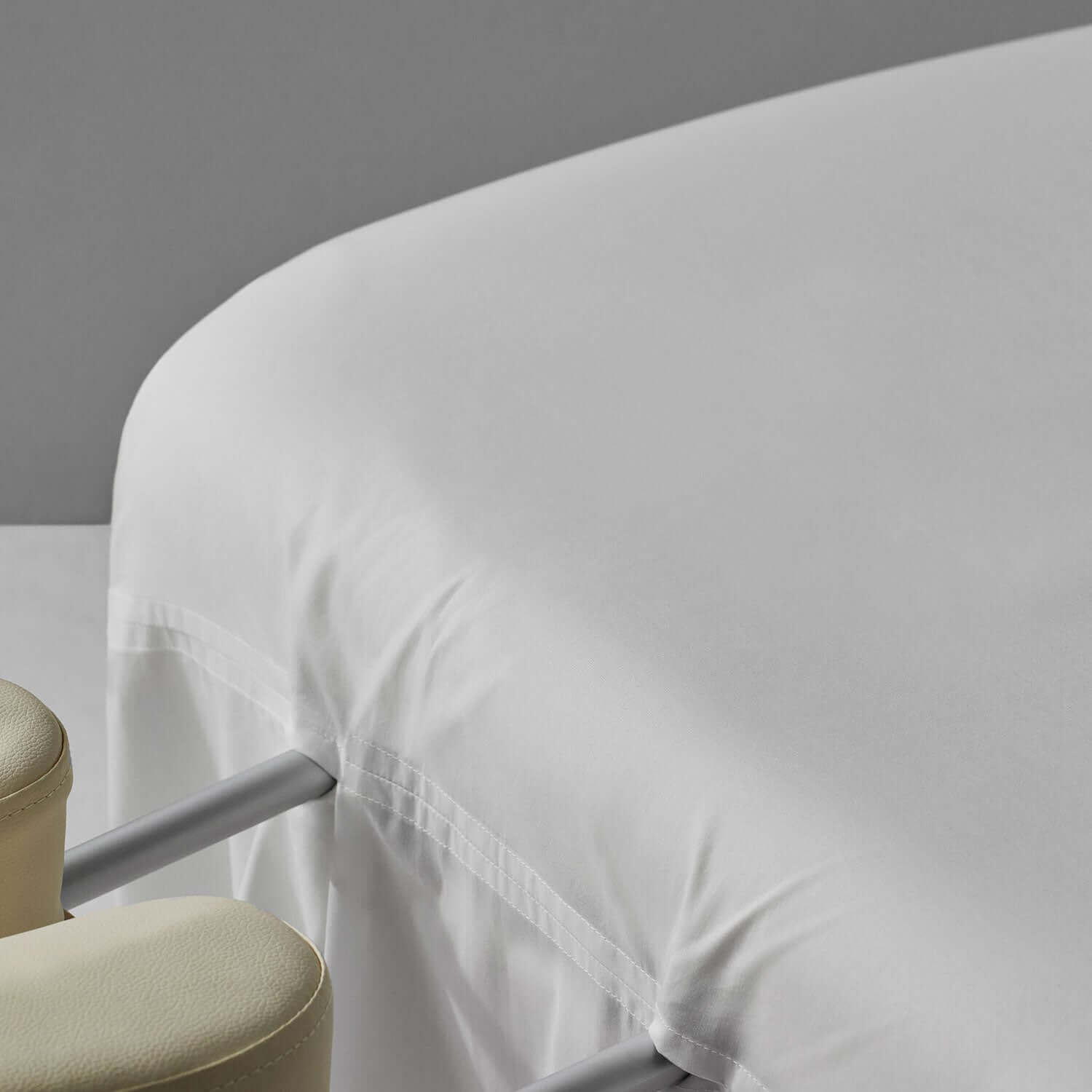 Serenity Sheet in pure white cotton on a massage table, featuring an extra-long skirt and easy face-cradle access.