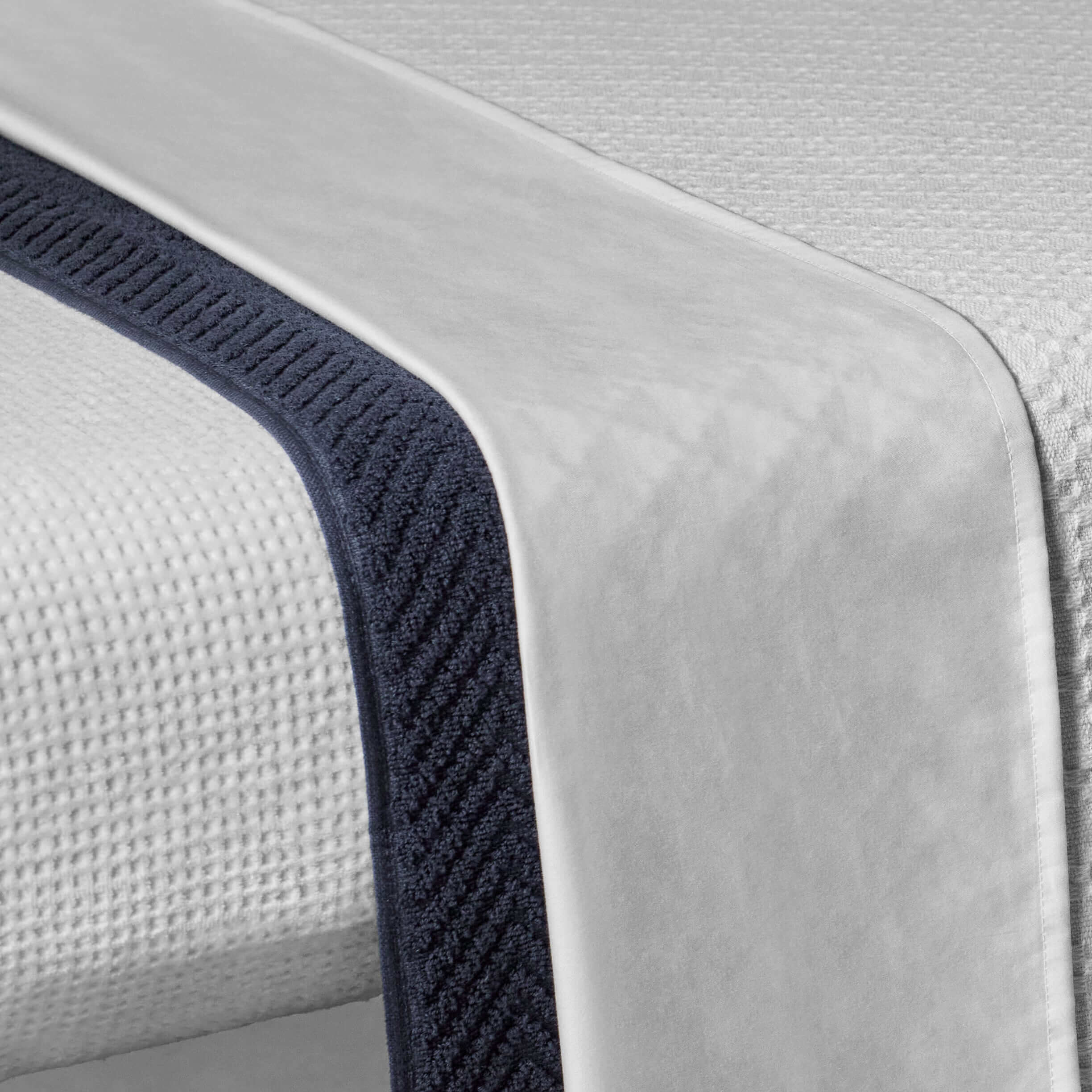 Close-up of luxurious velour sheet and textured massage table cover, enhancing relaxation and spa experiences.