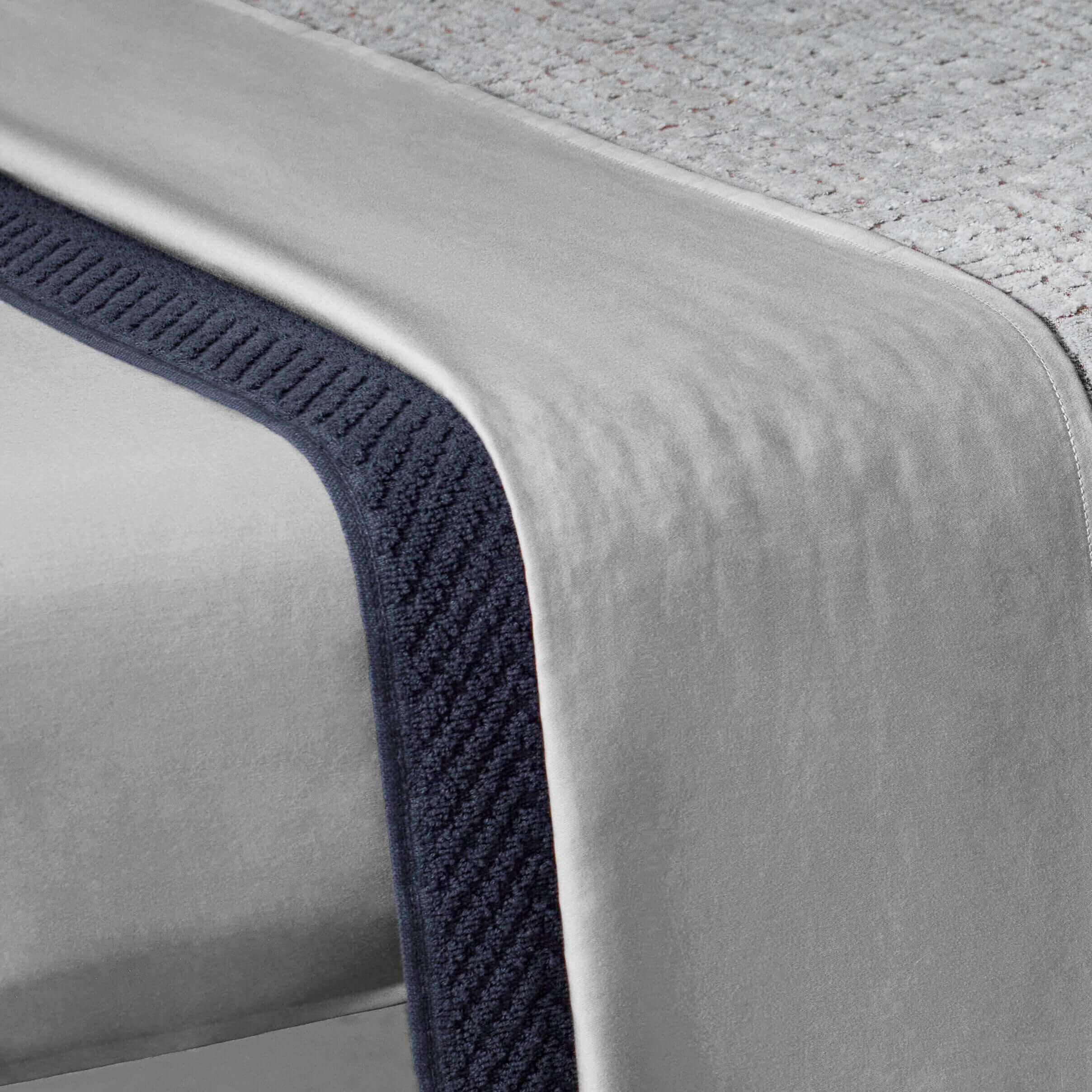 Fitted sheet in gray, showcasing a silky texture and a durable weave, perfect for spas and home massage therapy.