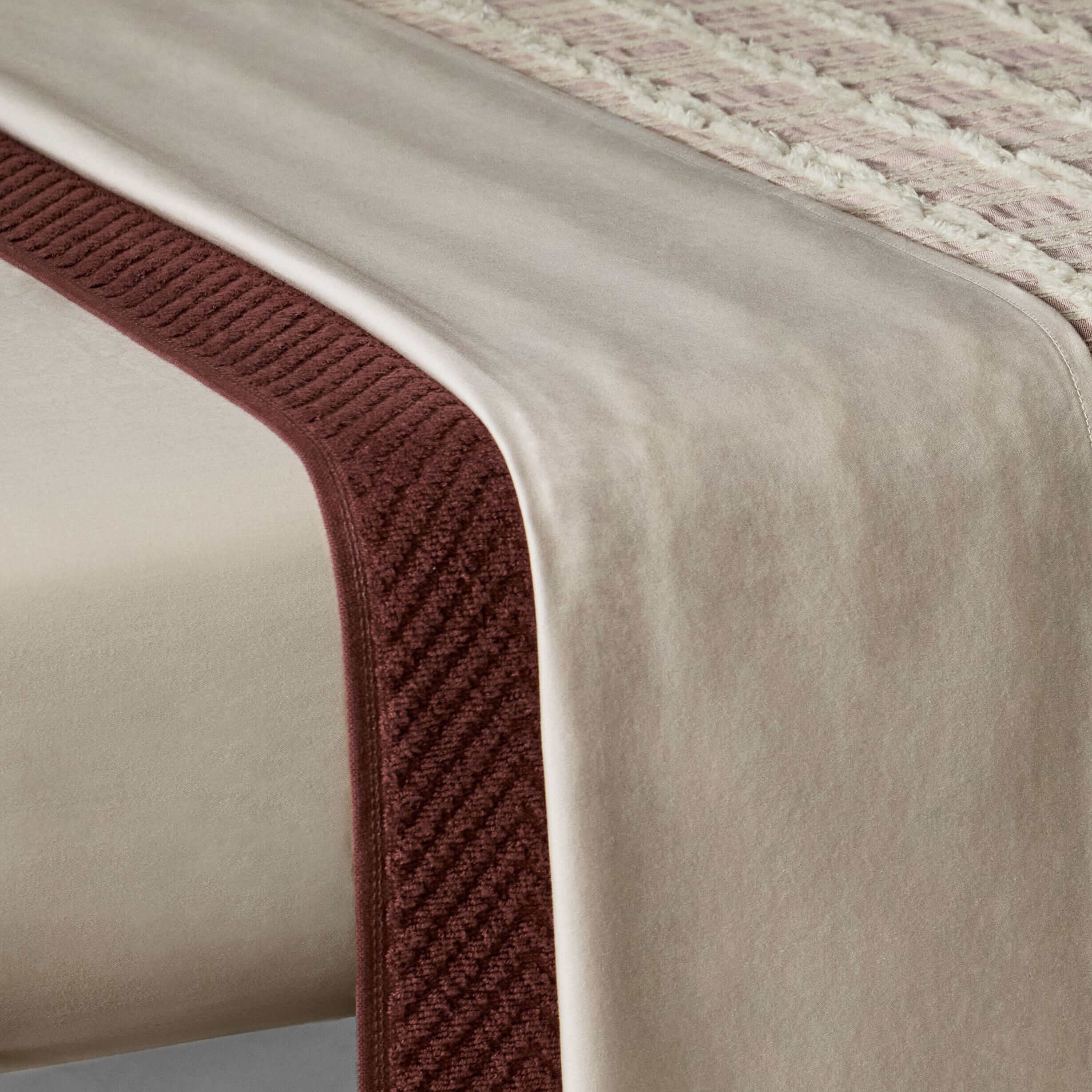 Fitted sheet in sand color with a silky feel, showcasing a subtle texture and elegant design, ideal for spas and home therapy.