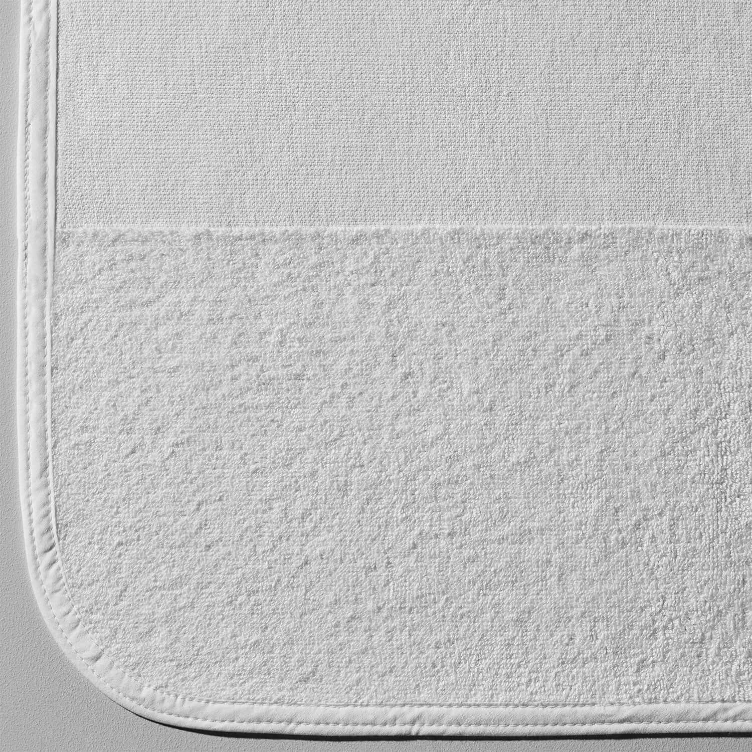 Close-up of white striped lounge chair cover, featuring a textured weave and soft terry cloth bottom for comfort.