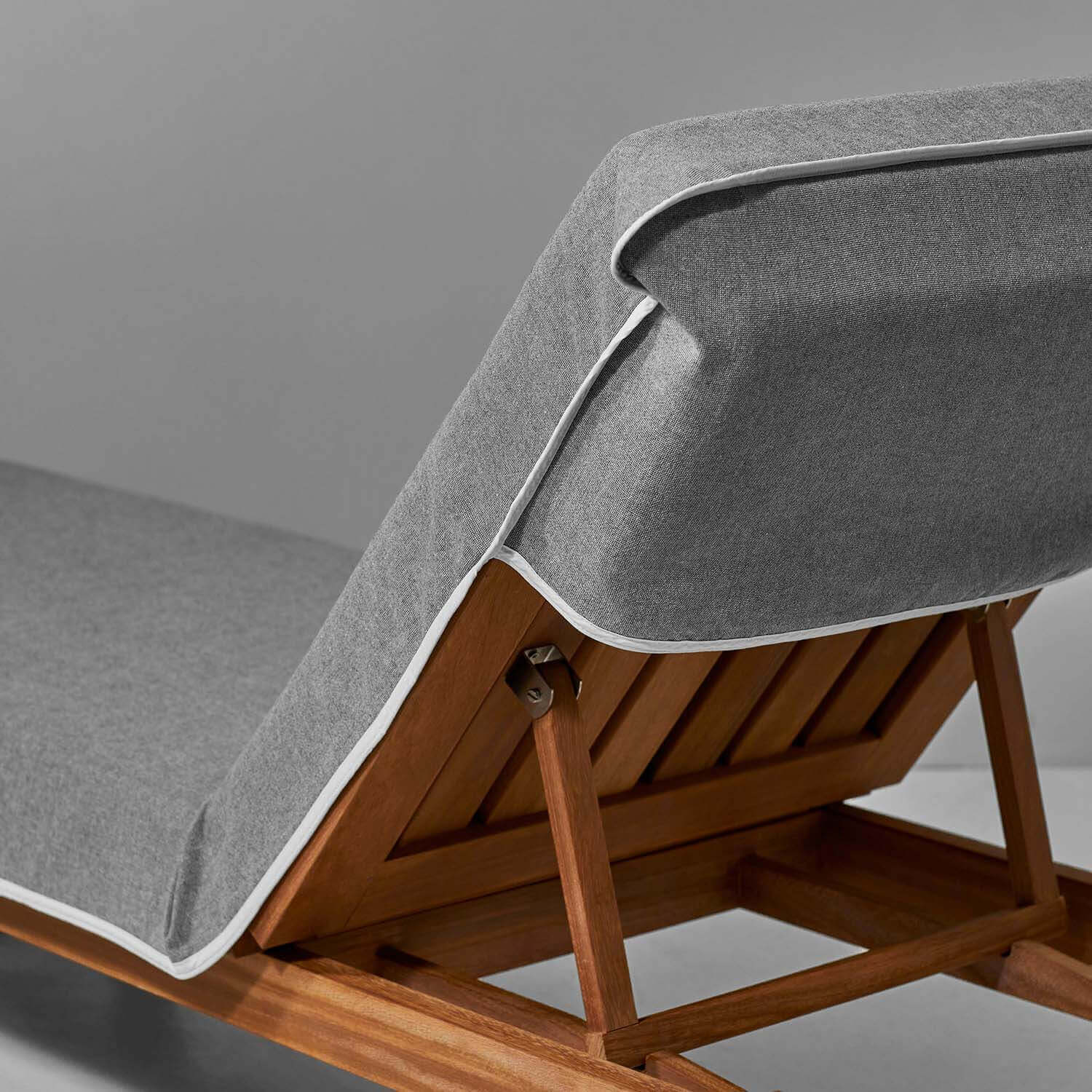 Gray SOL Lounge Chair Cover showcasing its secure-fit design and sleek wood frame, ideal for luxurious poolside relaxation.