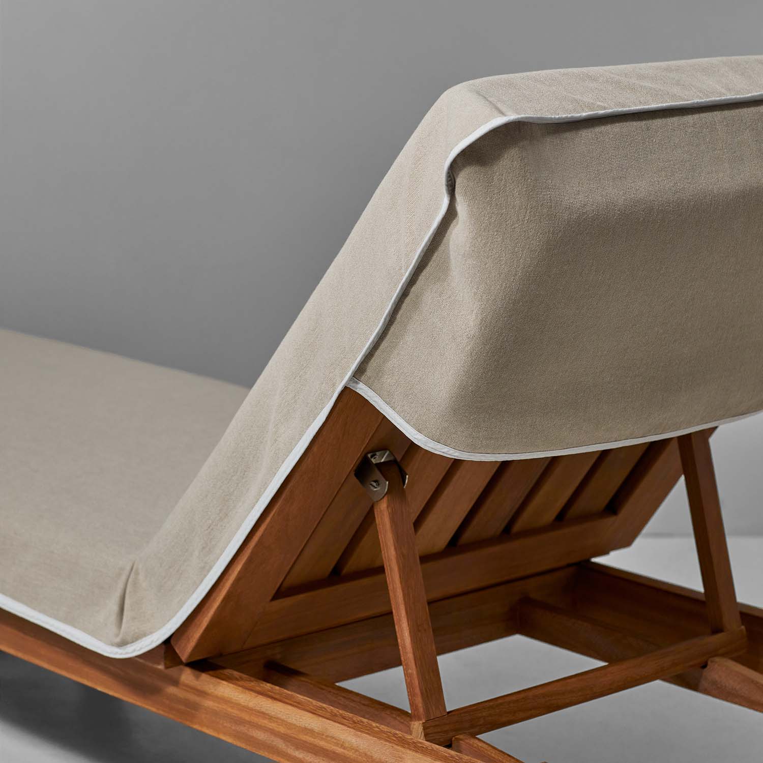 Sand-colored SOL Lounge Chair Cover on a wooden lounge chair, designed for comfort and style by resorts and spas.