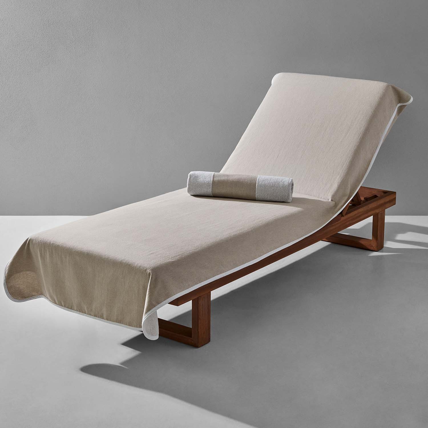 Elegant sand-colored lounge chair cover on a wooden chaise lounge, perfect for poolside relaxation.