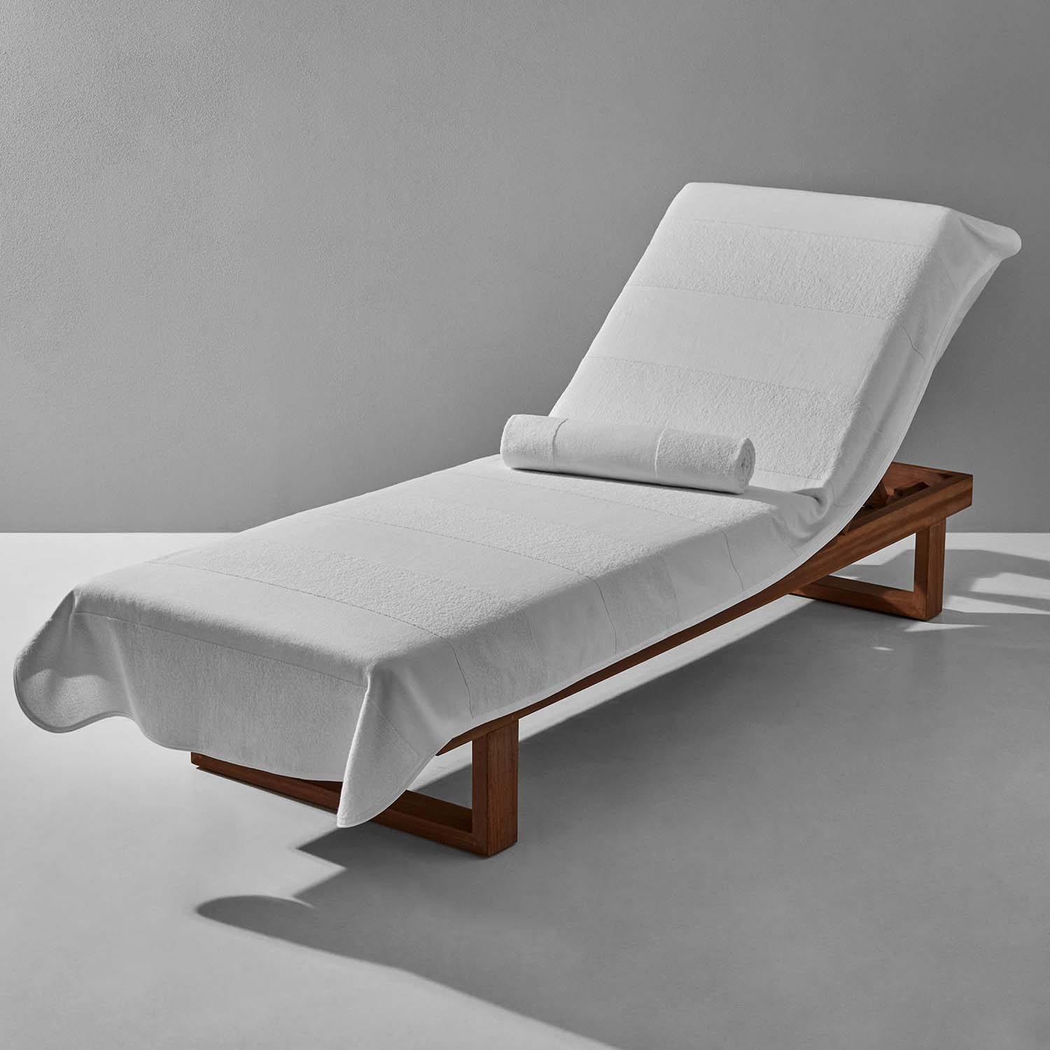 White striped lounge chair cover on a wooden frame, designed for comfort and style by five-star hotels and resorts.