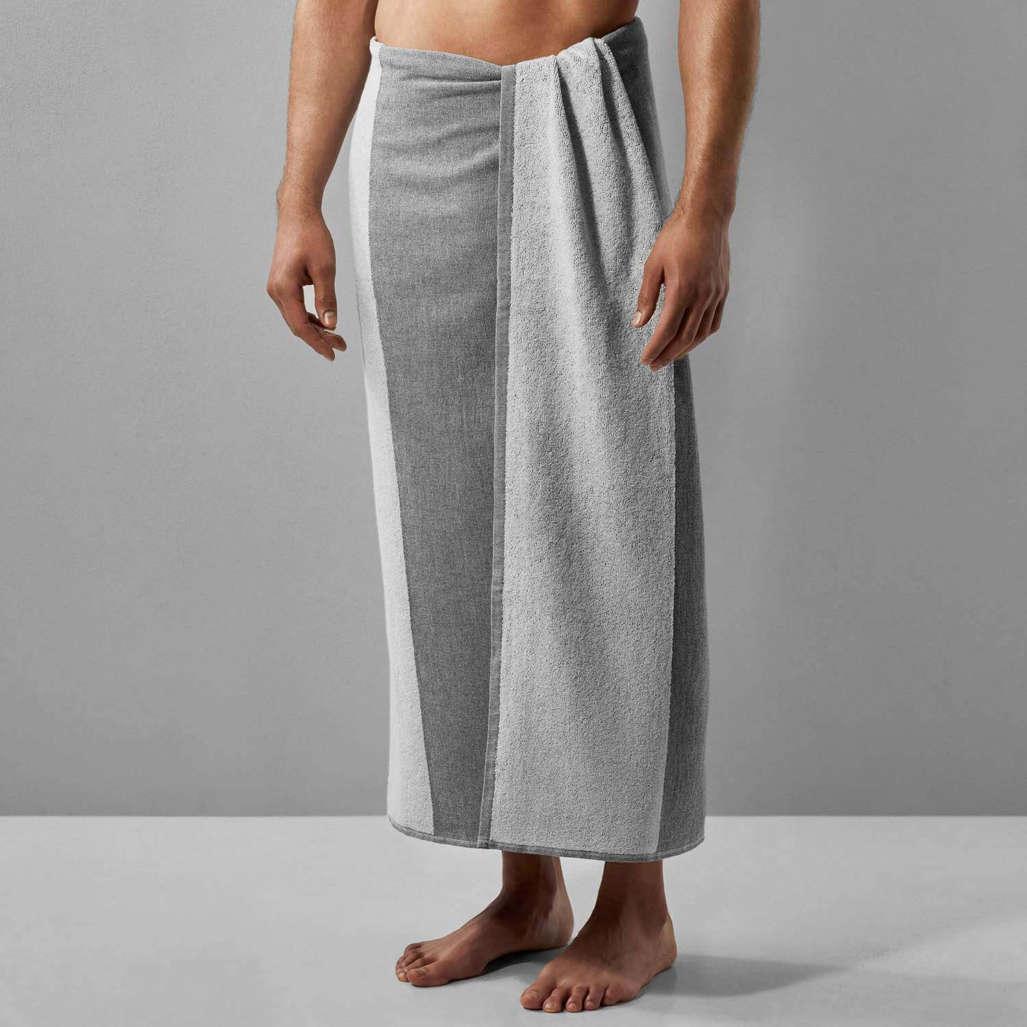 Adult male wearing a gray striped towel, ideal for beach, pool, or sports activities, showcasing eco-friendly innovation.