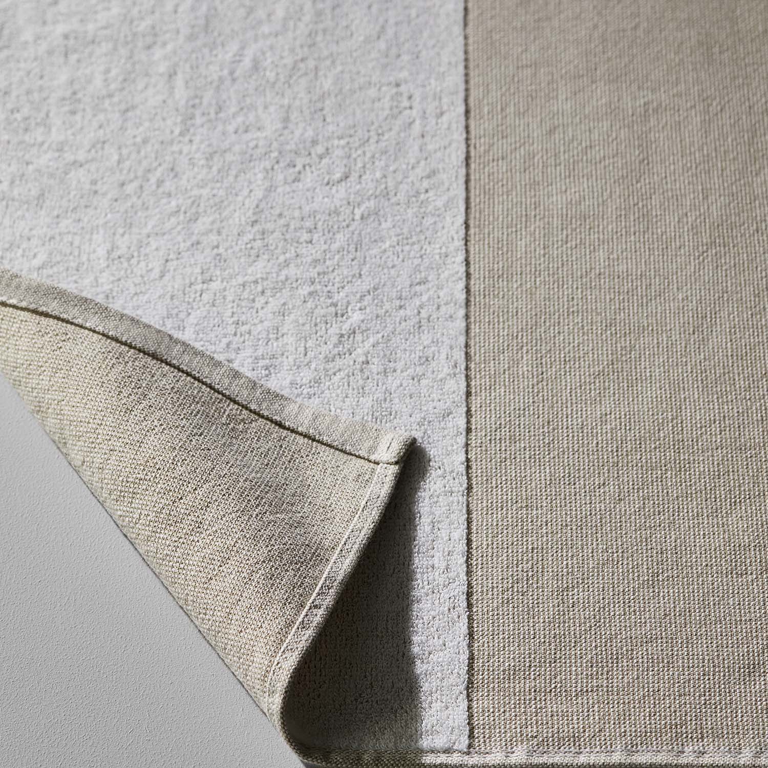Close-up of a SOL striped eco-towel showcasing its textured fabric and design, perfect for beach or pool use.