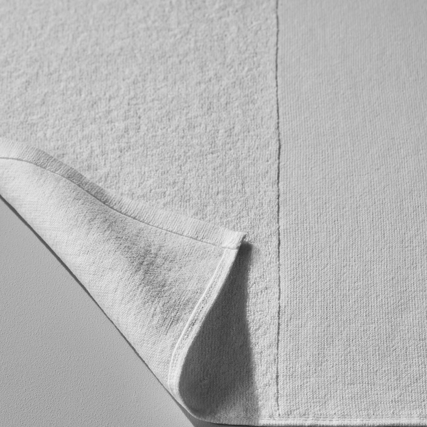 Close-up of a white SOL Striped Towel showcasing its soft texture and innovative design for beach and pool use.