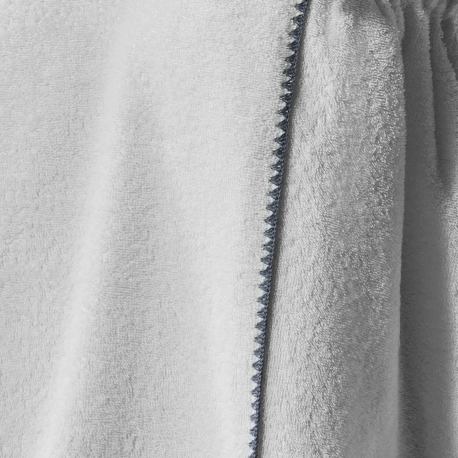 Close-up of Bordado Body Wrap in soft grey fabric, showcasing fine detailing and texture for spa use.