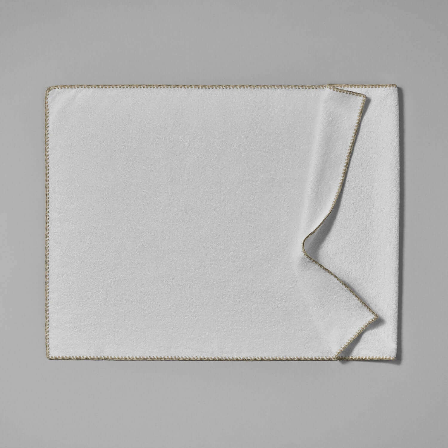 Luxurious Bordado Facial Towel in soft white with sand trim, ideal for spa treatments and daily self-care.