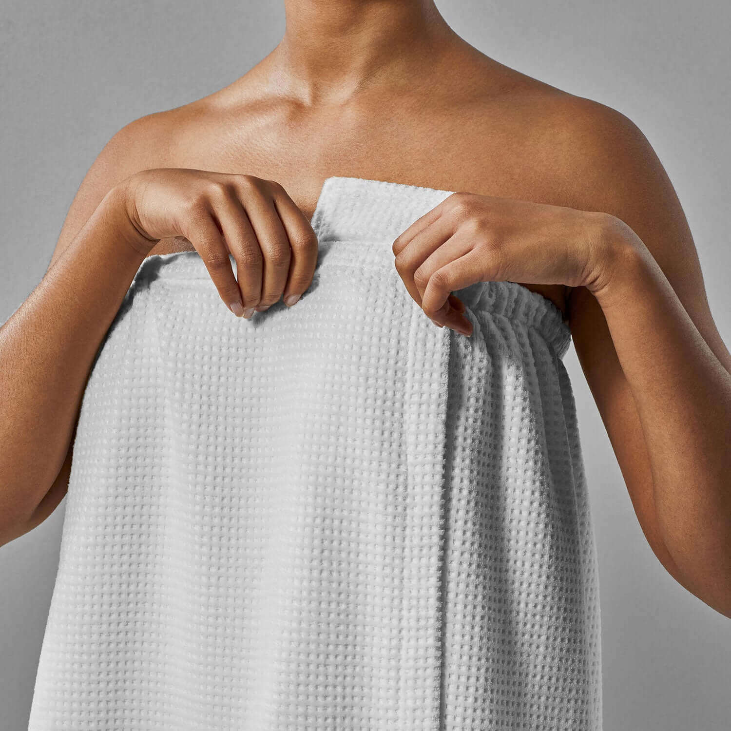 Unisex lightweight velour body wrap being adjusted for comfort during spa rituals, promoting modesty and ease of movement.