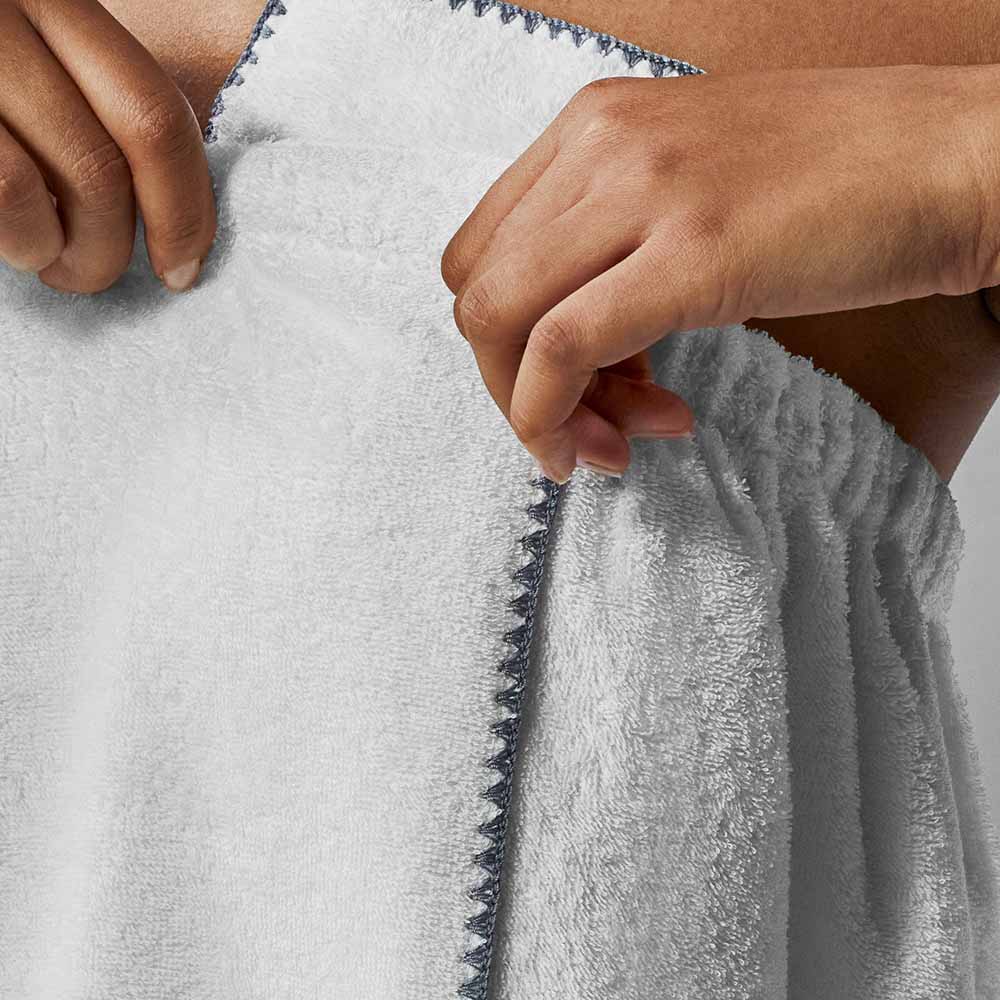 Close-up of hands adjusting a soft, fluffy white towel, showcasing its texture and quality.