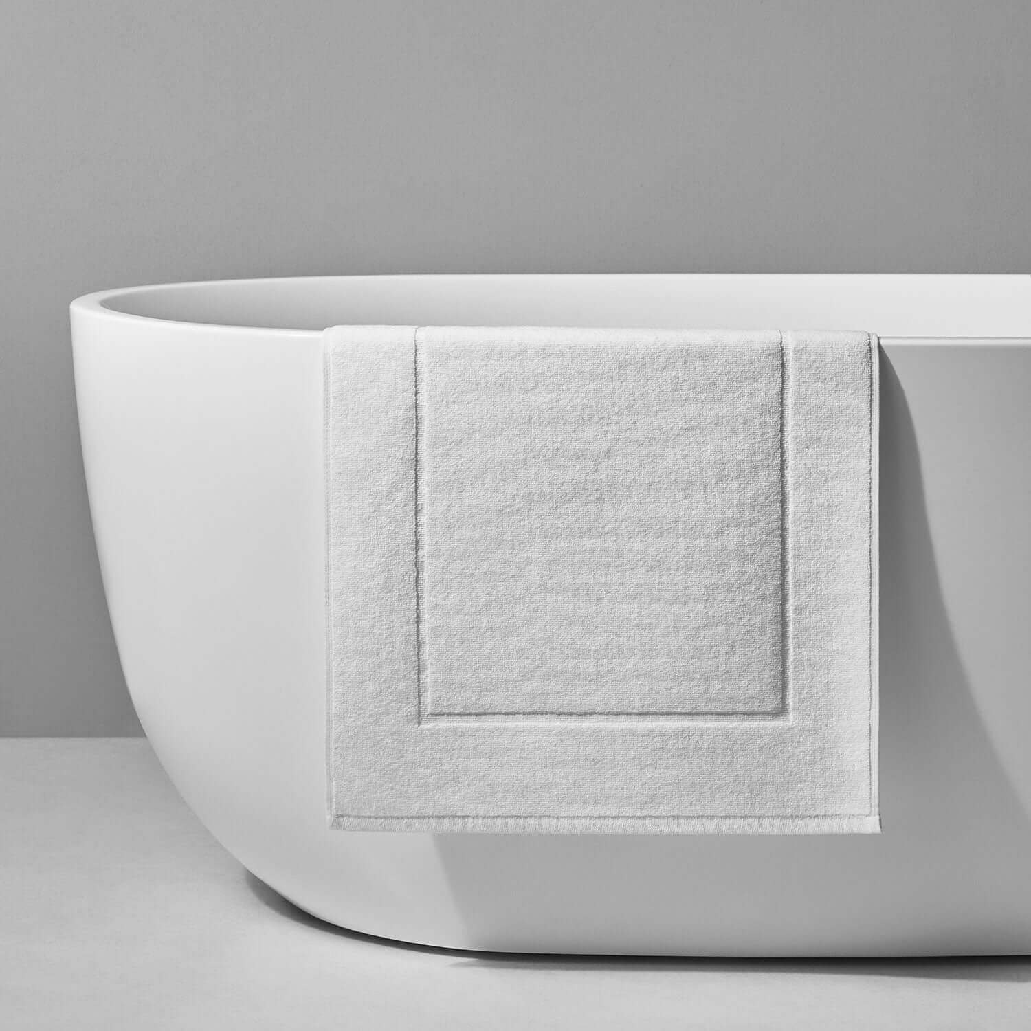 Elegant white Terry Mat displayed on a modern bathtub, showcasing its durable and slip-resistant design.